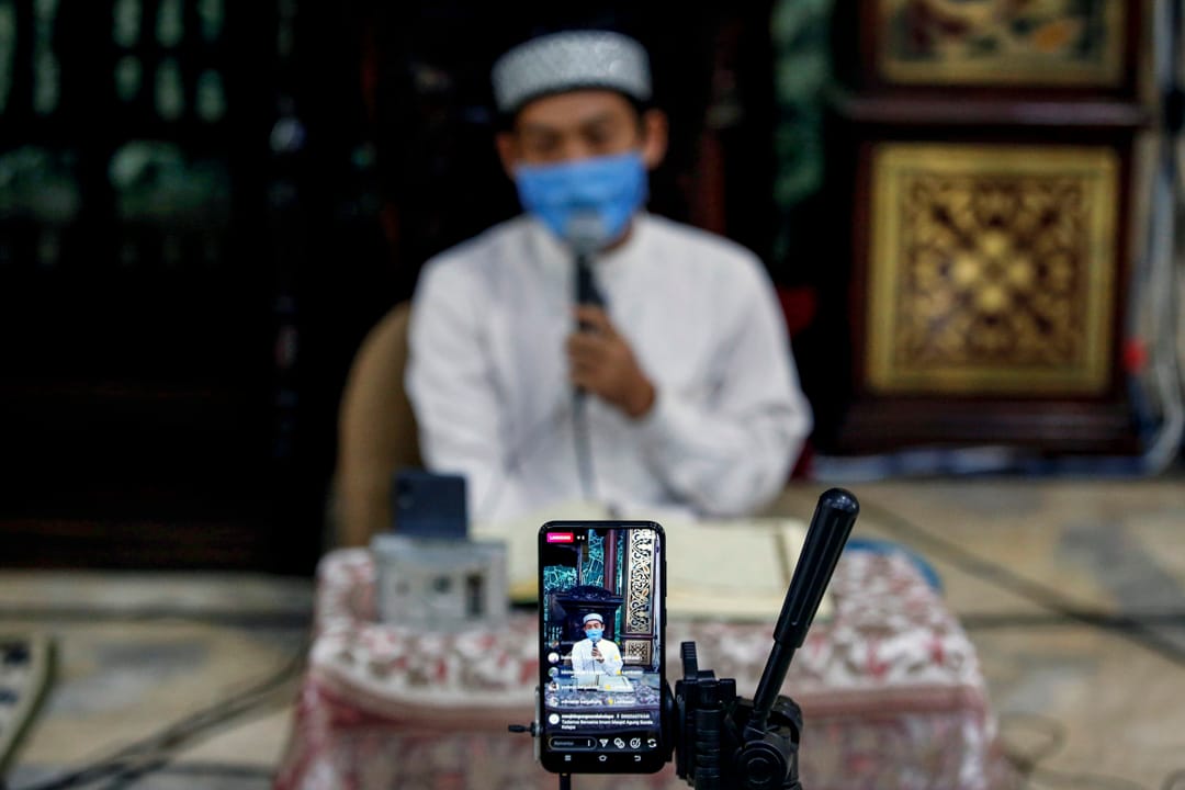 2020年4月25日,斋戒月,戴著口罩的穆斯林在清真寺内朗读《古兰经》,透过社交媒体传播出去。