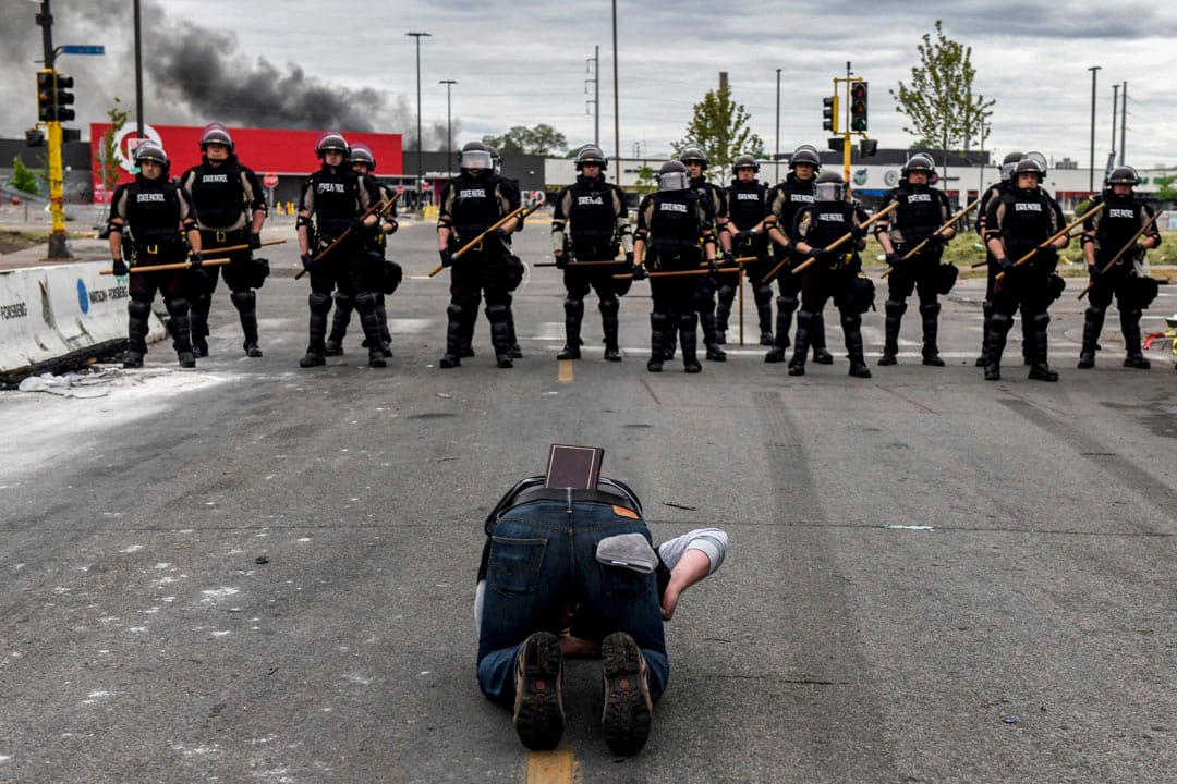  2020年5月29日美国明尼苏达州阿波利斯市，一名被拒绝通过封锁区的居民跪在地上于警察前哭泣。