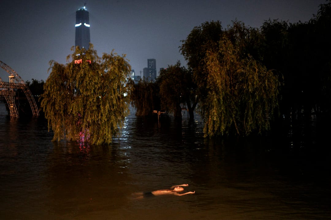 2020年7月9日，湖北武汉，居民在一个被洪水淹没的公园游泳。