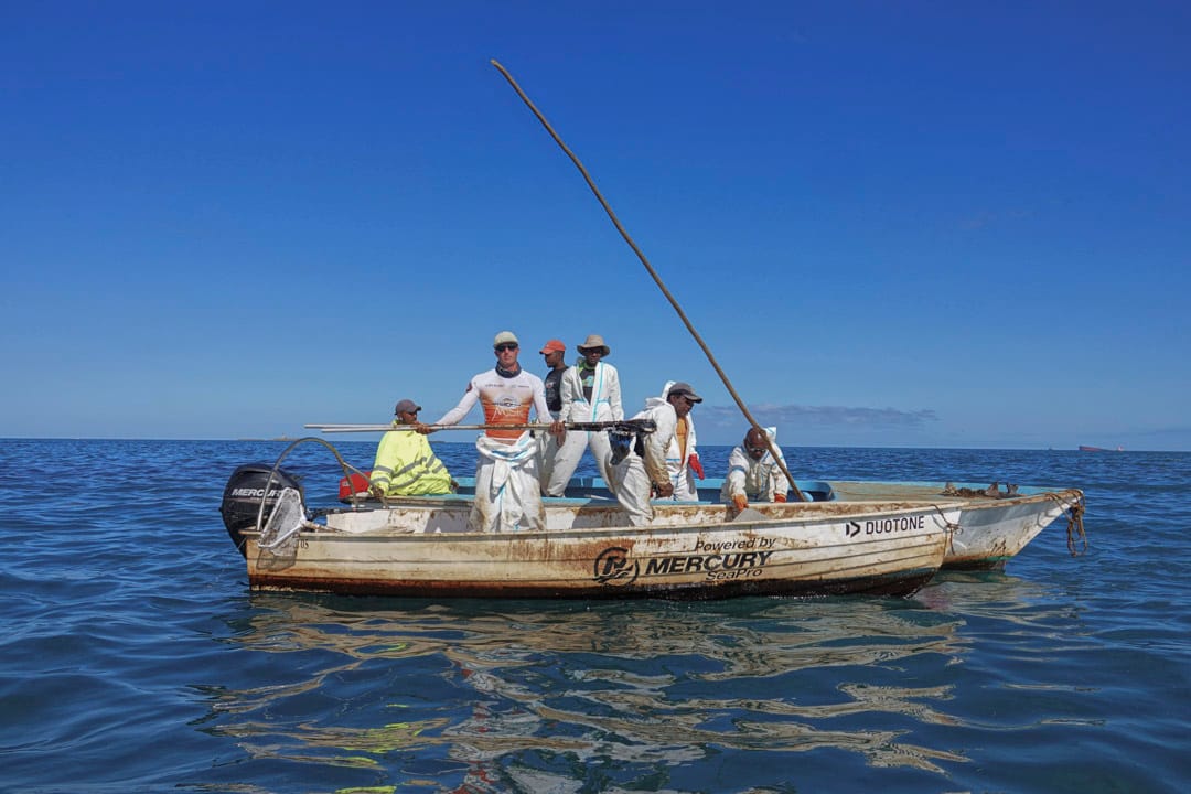 漁民在「若潮號」擱淺的附近海域清理油污。