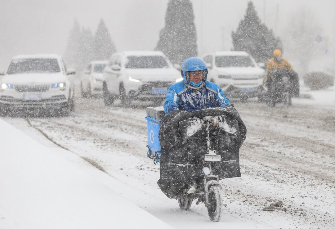 2021年1月6日,遼寧暴風雪期間,餓了麼外賣員在公路駕車送餐。