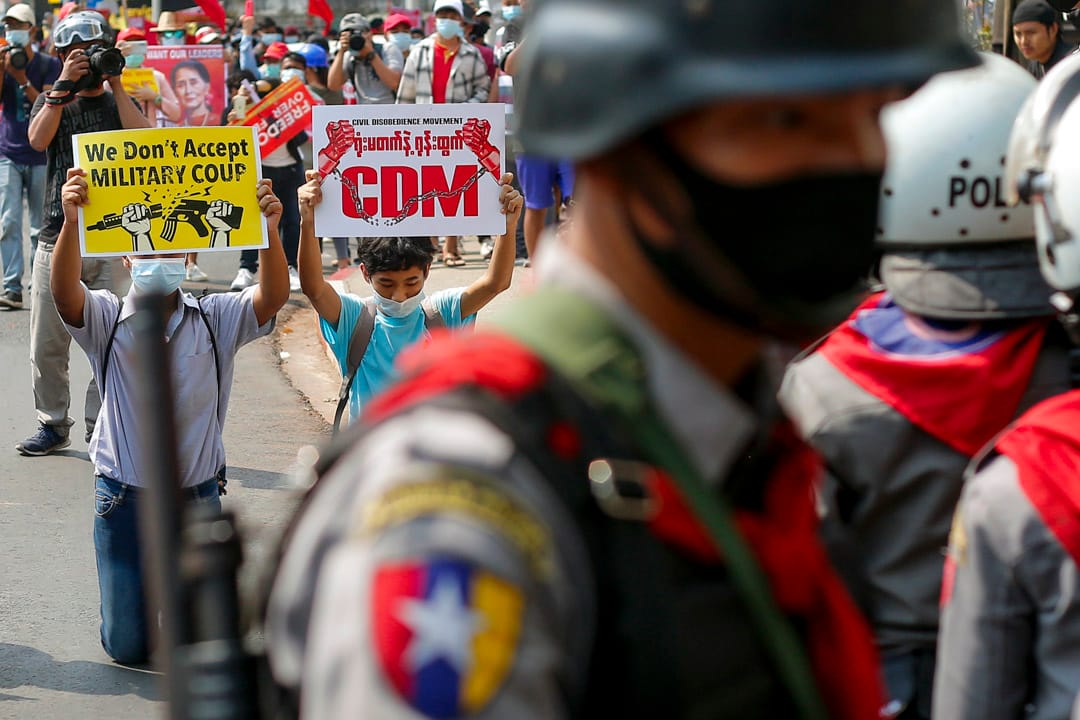 2021年2月19日緬甸仰光,反對軍政府的示威遊行中,緬甸示威者舉著牌子跪在防暴警察面前。