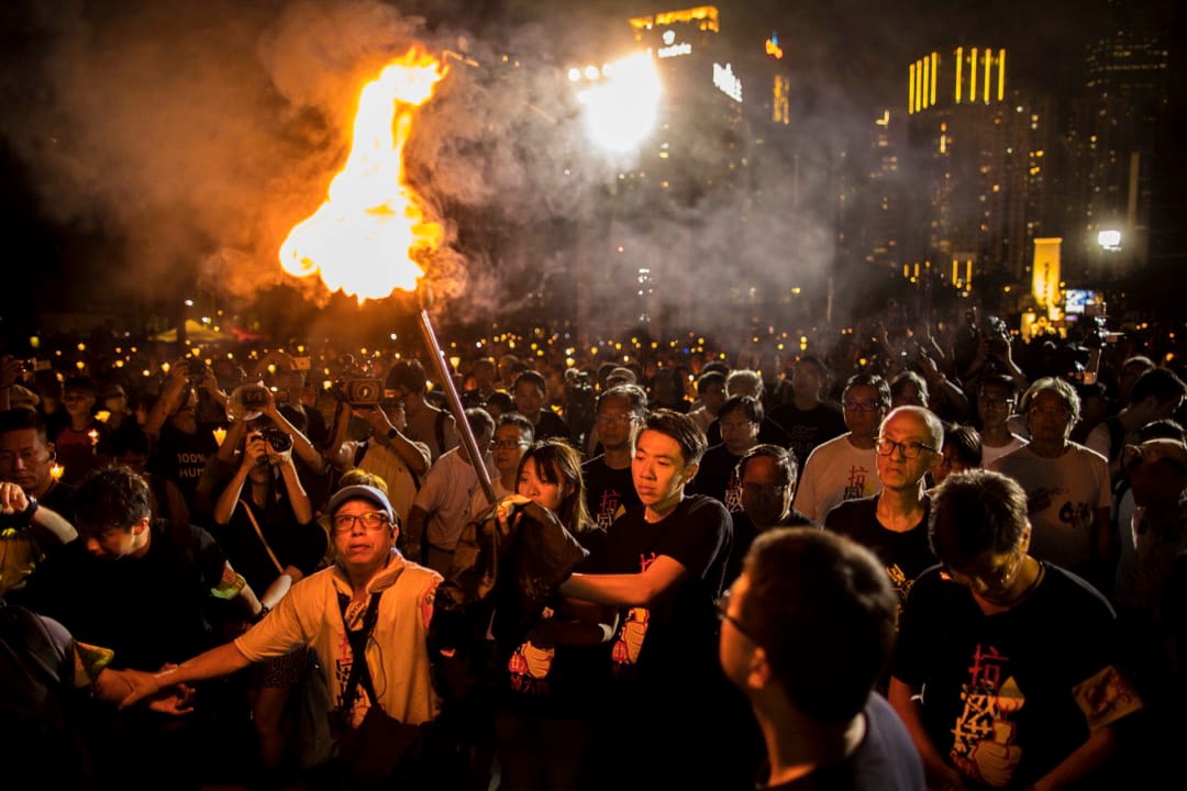 2018年6月4日，“悼六四、抗威权”烛光晚会上，支联会常委与年青人燃点火炬步向舞台。