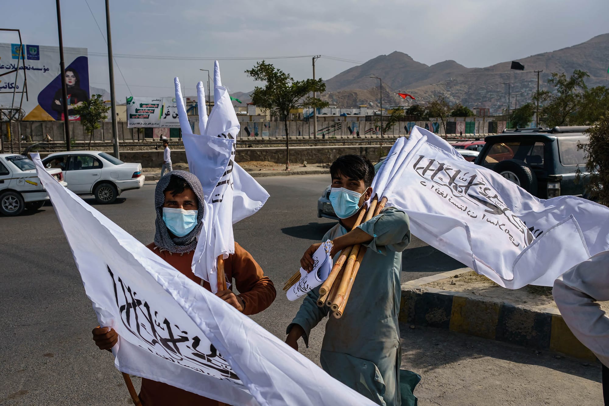 2021年8月20日阿富汗喀布爾,阿富汗年輕男孩在十字路口出售塔利班旗幟。