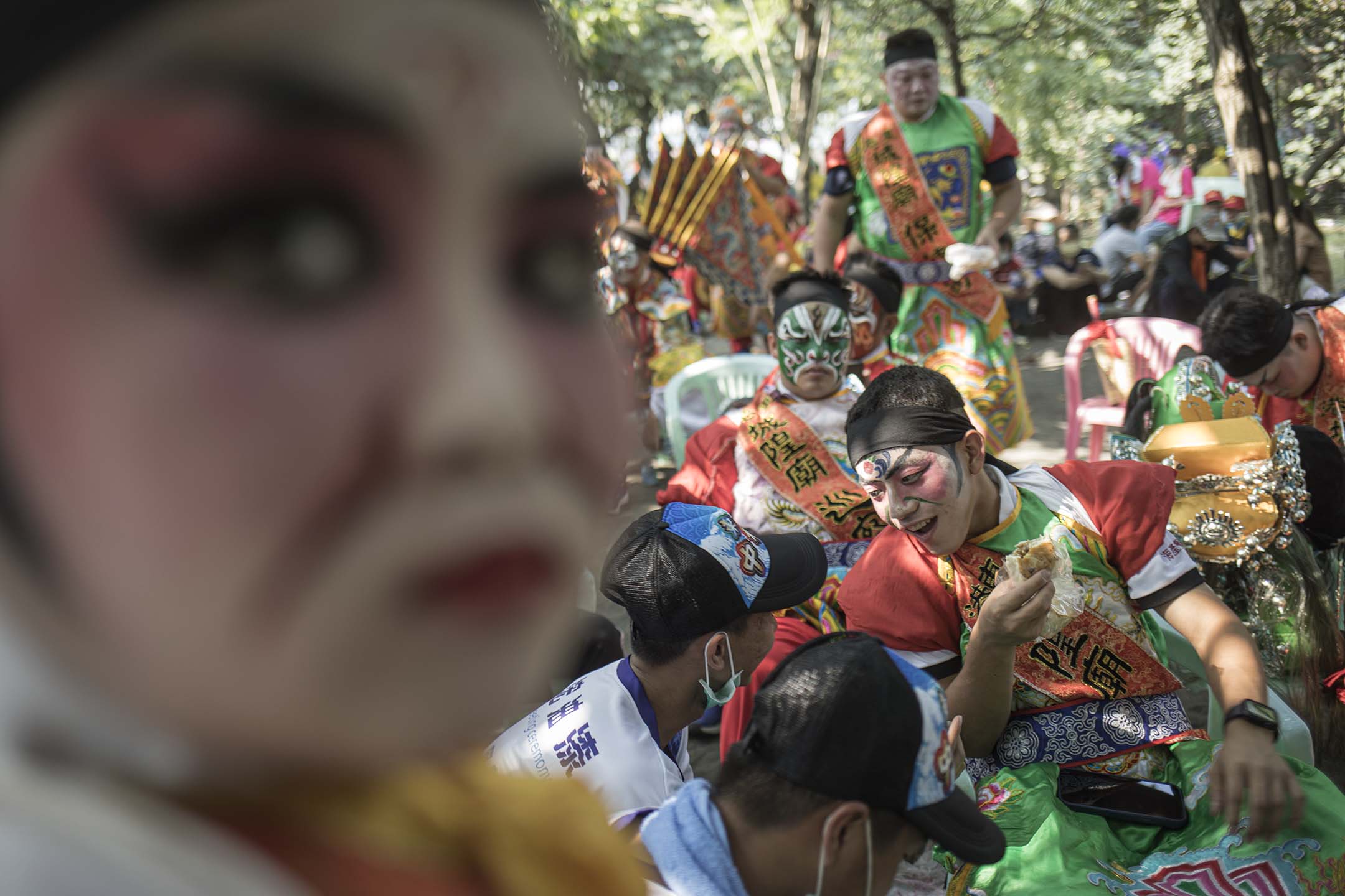 2021年10月24日屏東東港,等待“請水”的陣頭隊伍在樹蔭下吃飯。