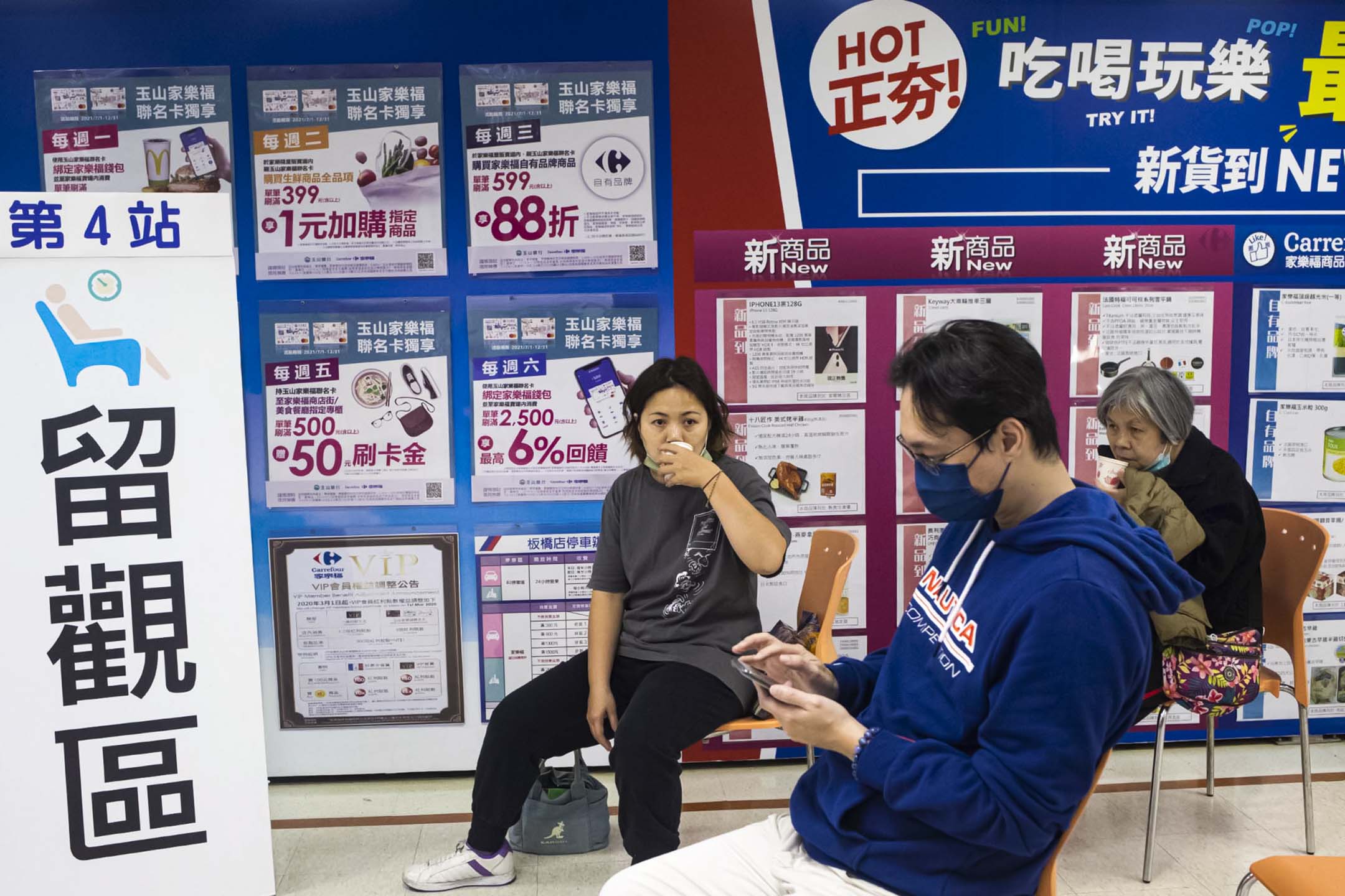 2021年12月9日板桥家乐福,市民接种疫苗后在留观区喝茶休息。