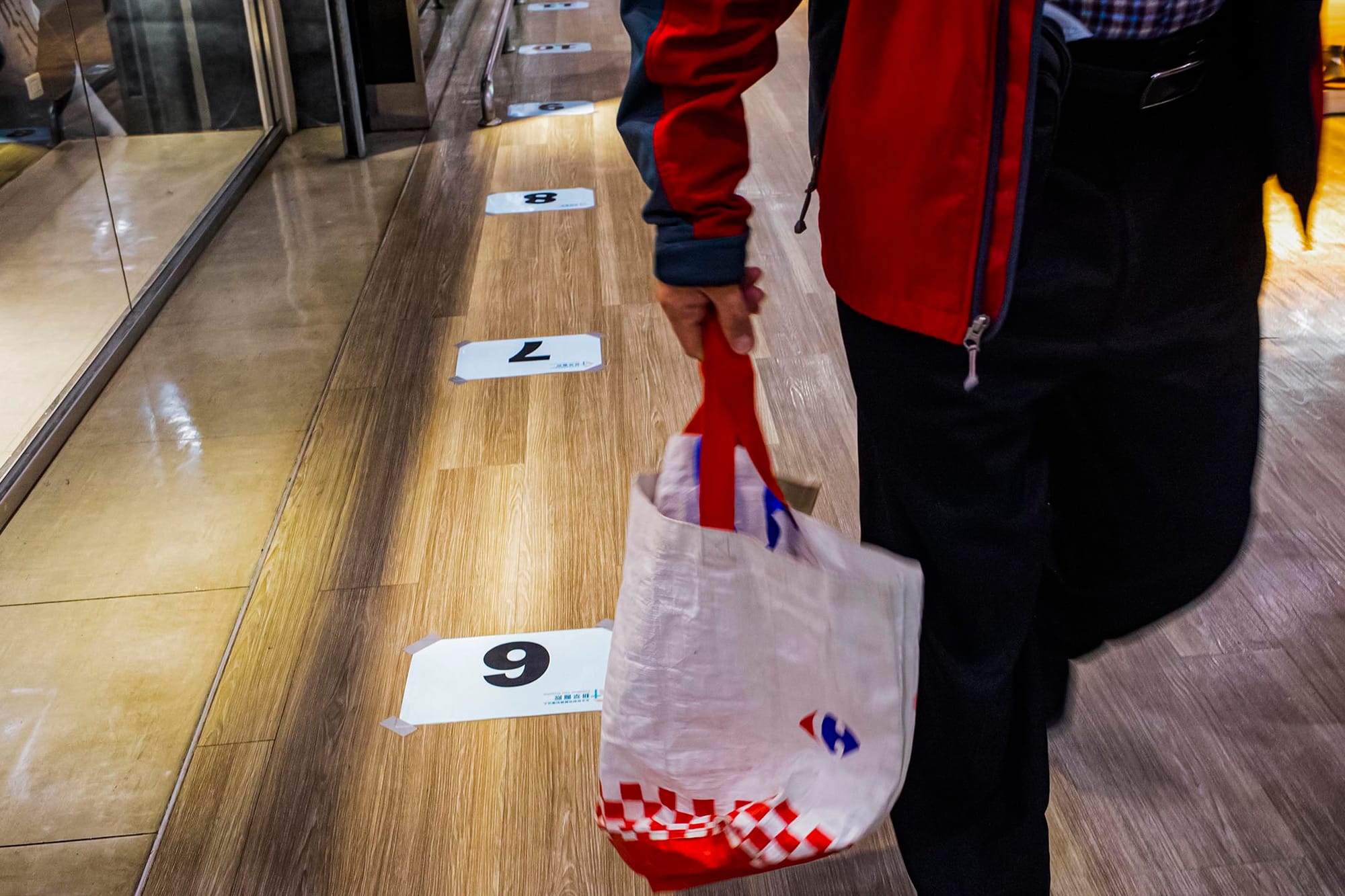 2021年12月10日新店家乐福,商场的地上贴上排队打疫苗的标示。