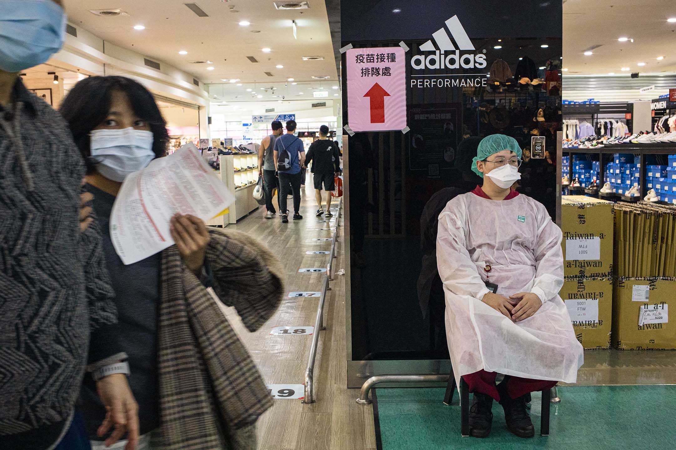 2021年12月10日新店家乐福,医护人员在接种疫苗处工作。