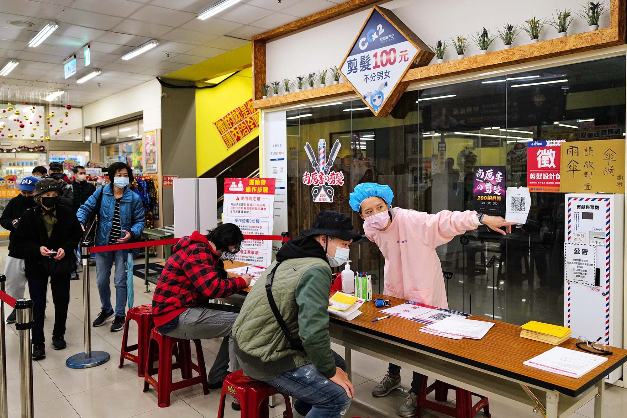 2021年12月6日板桥全联超市,工作人员指示市民接种疫苗的地方。
