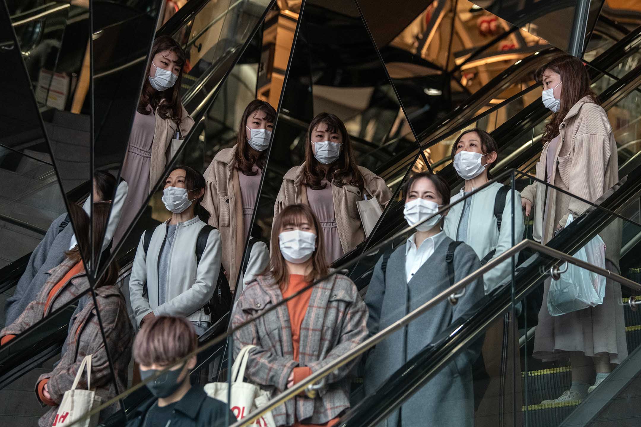 2020年4月3日日本東京，戴著口罩的人們從自動扶梯下樓。