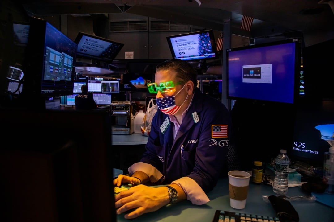 2021年12月31日，美国纽约交易所，一名戴著“2022”字样眼镜的交易员在电脑前工作。