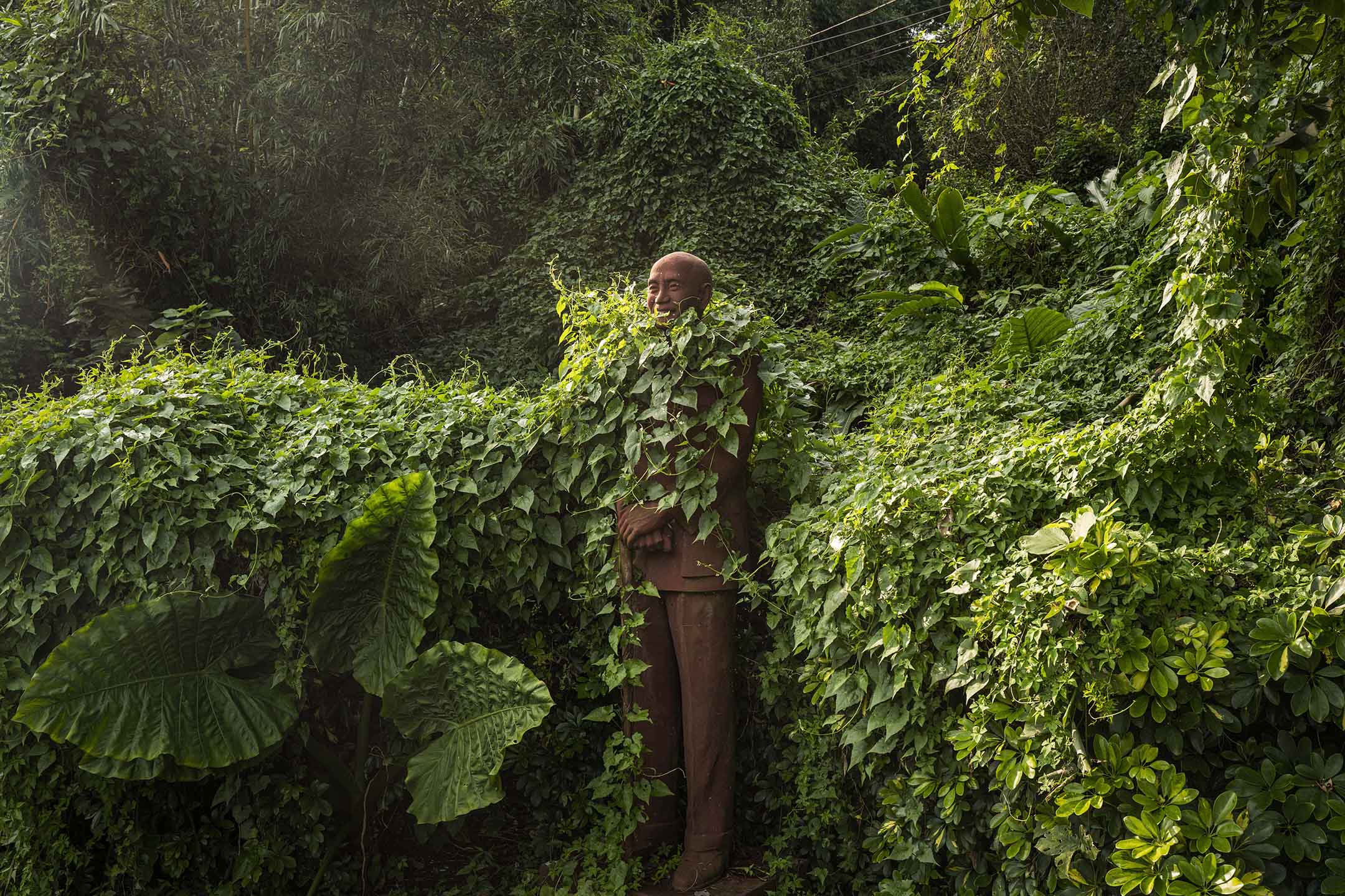2021年9月19日桃园慈湖，一尊蒋介石像被山上的植物包围。