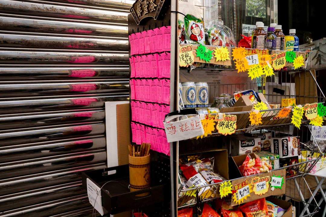 门外的零食架的一侧放了一个签筒,又挂着几行粉红色签纸,签文全是来自艺术家的箴言。这是漫游乐园在半杯寮设置的“艺灵签”。