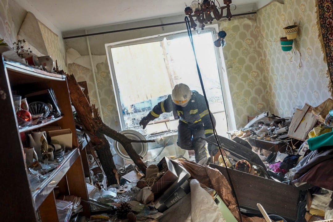 2022年2月24日,烏克蘭東北部城市楚胡伊夫,俄羅斯發動空襲擊中民居,一名消防員在瓦礫中進行搜救工作。