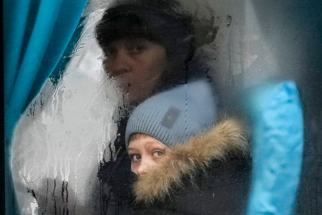 2022年2月24日,一名女士和女童坐車離開烏克蘭東部的盧甘斯克地區,二人凝視著窗外。