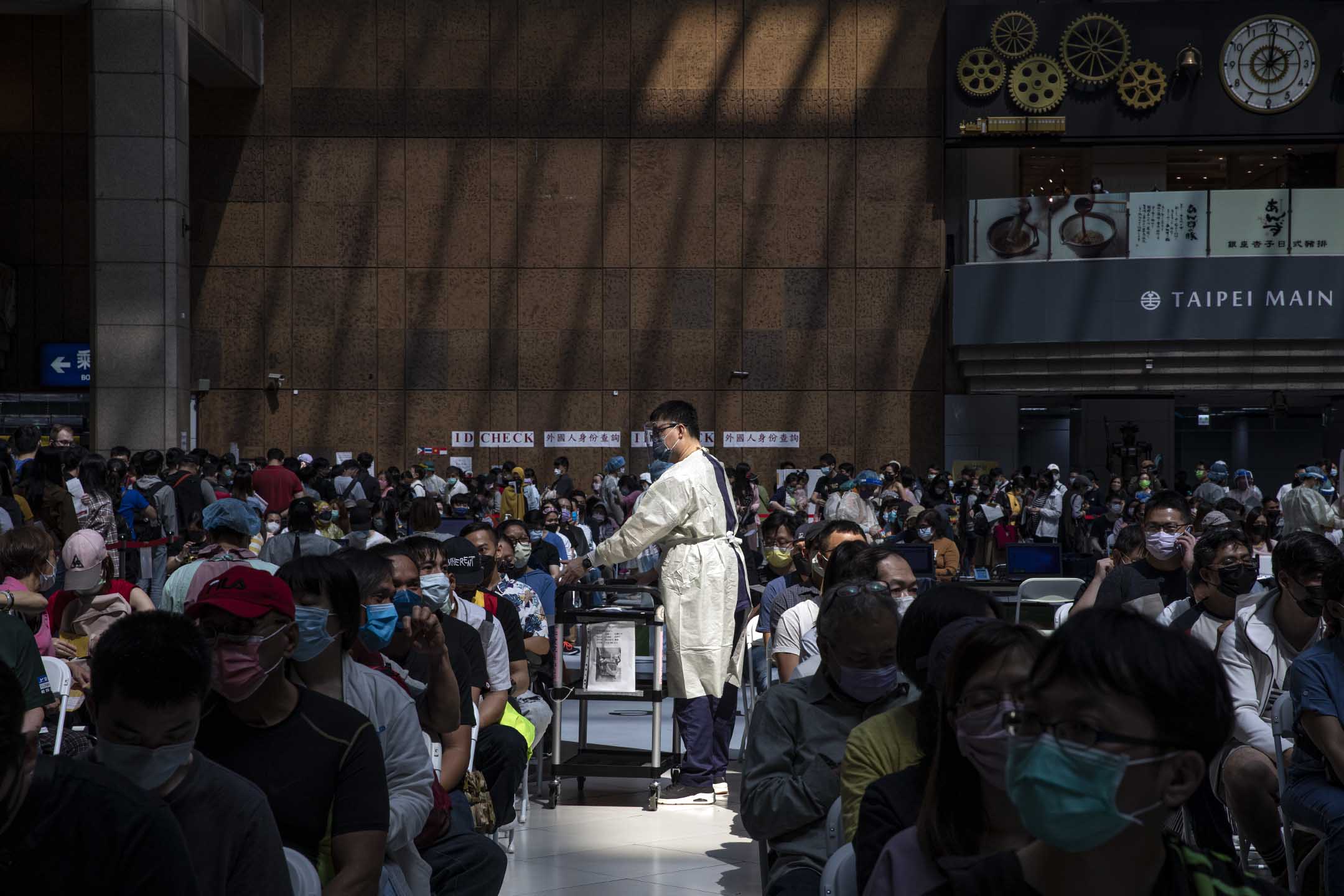 2022年4月23日,台北車站,一名醫護人員為等待接種疫苗的人收集資料。