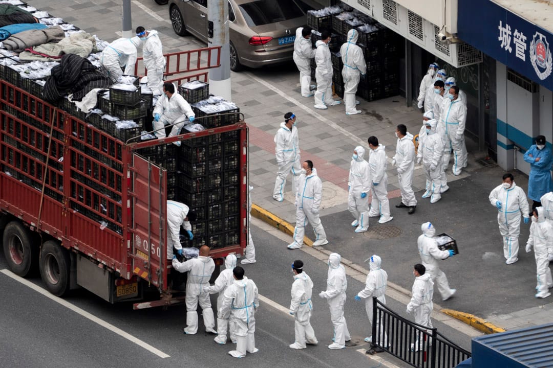 2022年4月5日,上海封城期間,政府為市民提供物資,工人在一條街道上卸下和搬運物資。