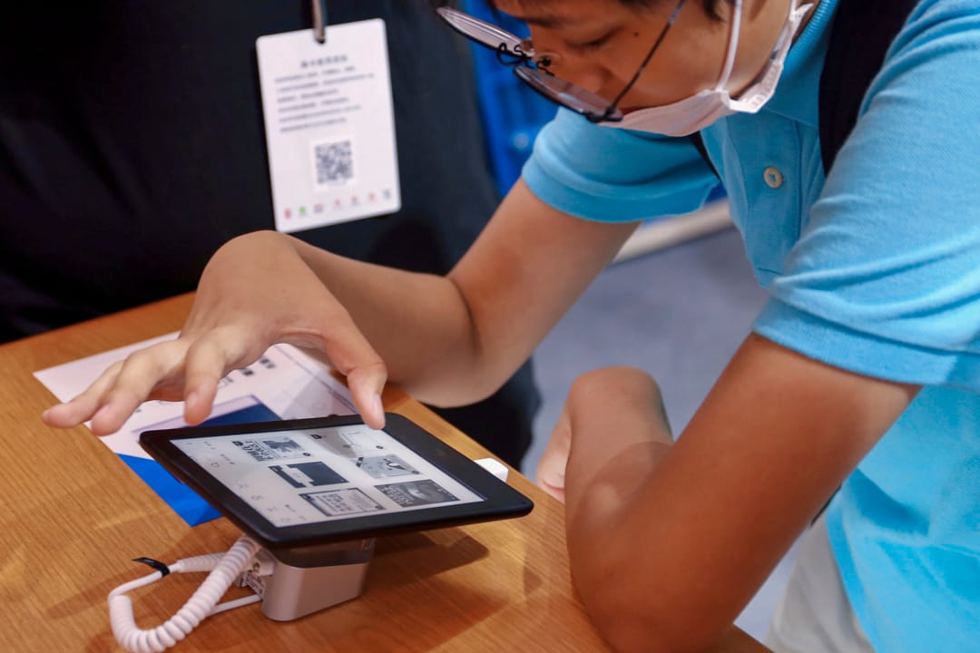 2020年8月12日,一位顧客在上海書展的Kindle攤位試閱電子書。