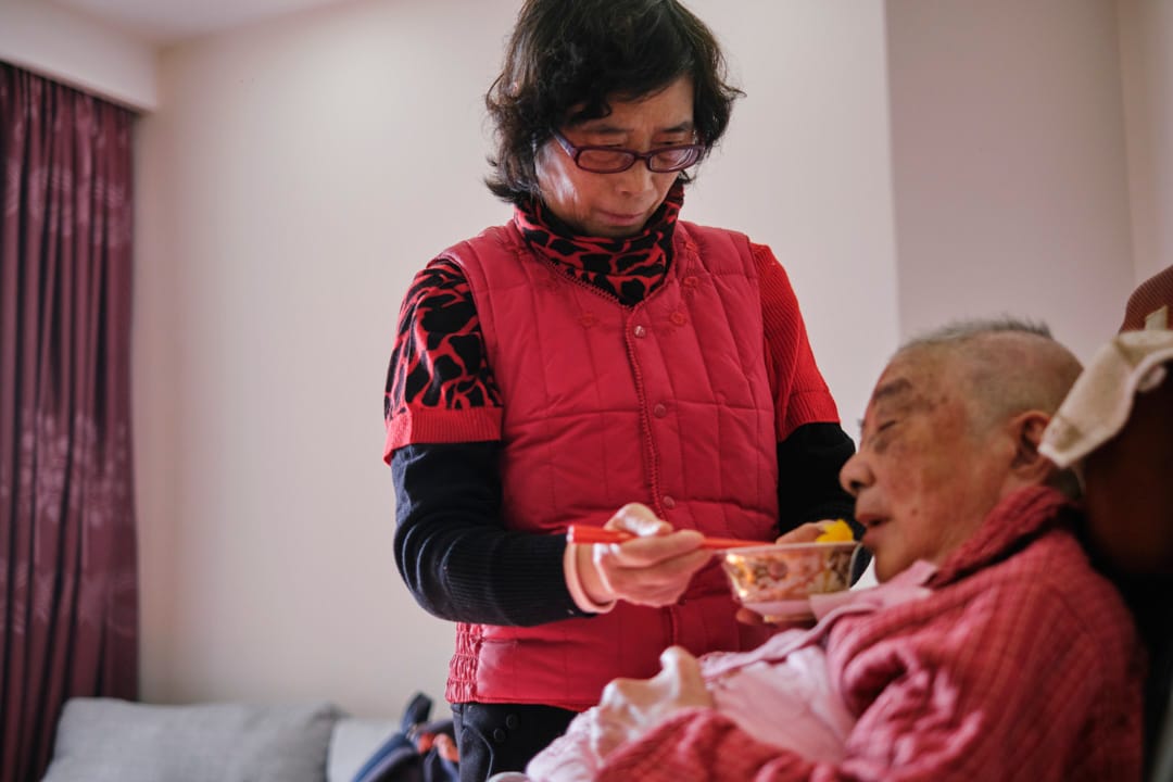 洗浴过后的下午,朱和珍喂母亲陈菊清吃水果和点心。