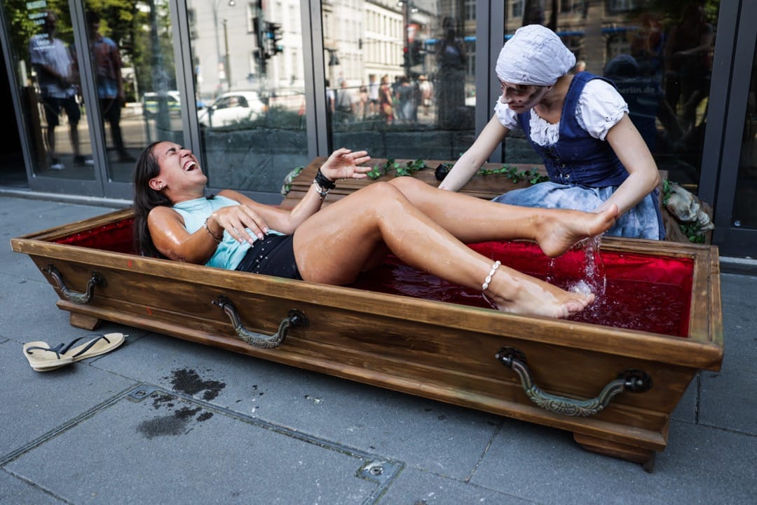 2022年7月20日,德国柏林,一个古堡地牢主题游乐设施用载满水的道具棺材为前来的游客降温。