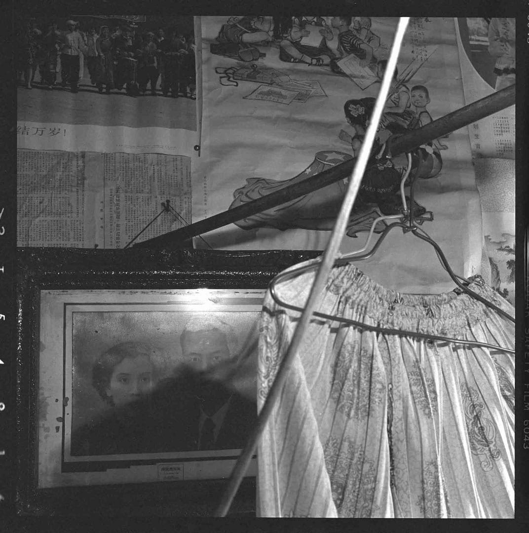 1981年﹐广州家庭，墙上《全国人民大团结万岁》宣传画、《捎个信儿给台湾小朋友》宣传画、民国时的结婚照、糊墙的《参考消息》。