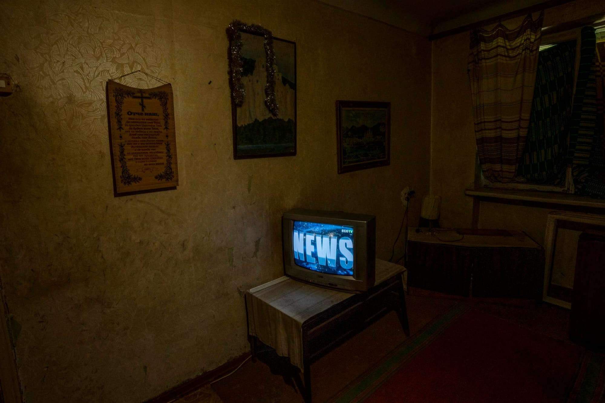 2022年7月6日，乌克兰东部克拉马托尔斯克，独居并拒绝撤离的 70 岁老人在公寓里看电视新闻。