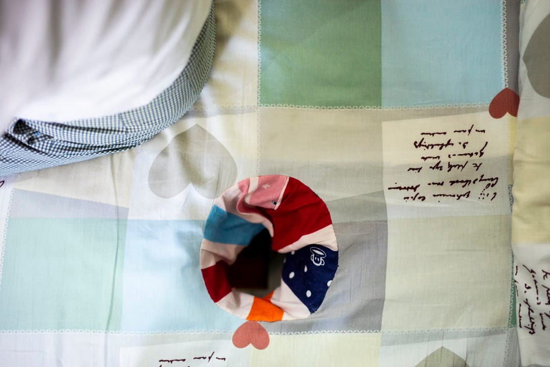 David工作的一张按摩床，床单是浅色的格子，印有灰色的心形图案。