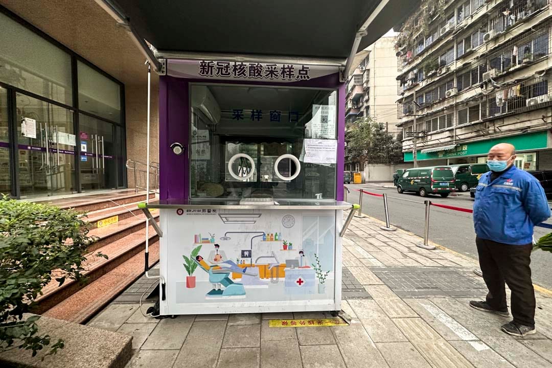 2022年12月8日，中国成都，一名工作人员在拆除一组核酸检测采样站。