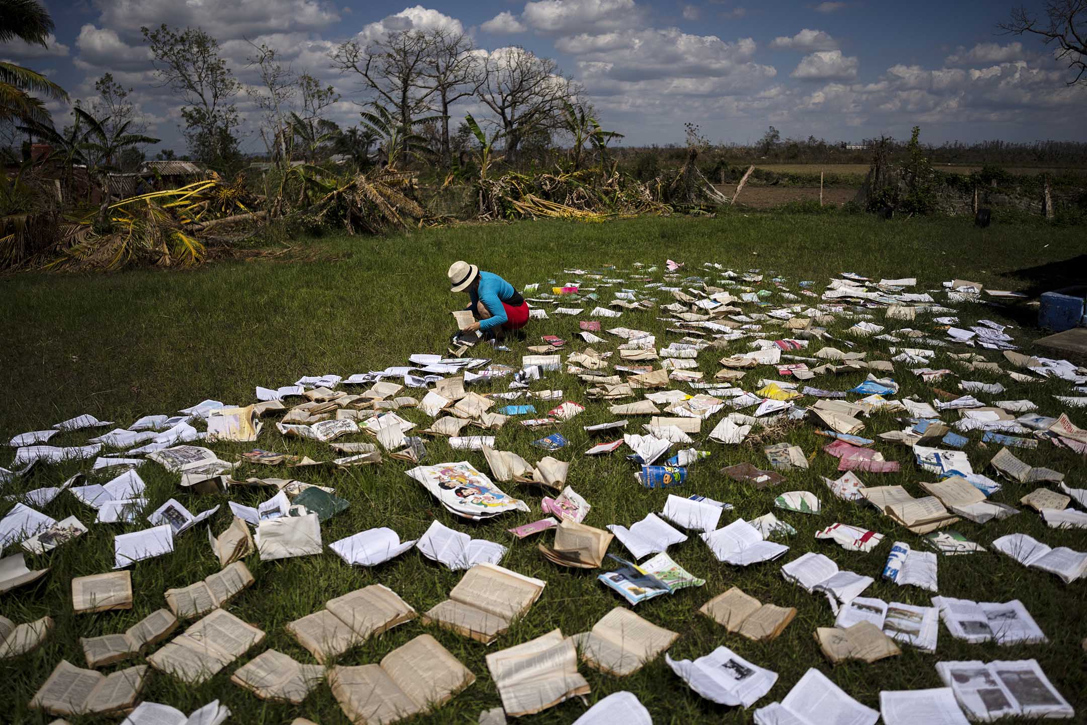 2022年10月5日，古巴比那尔德里奥省，一名老师在一所被飓风严重破坏的学校里晾干书本。