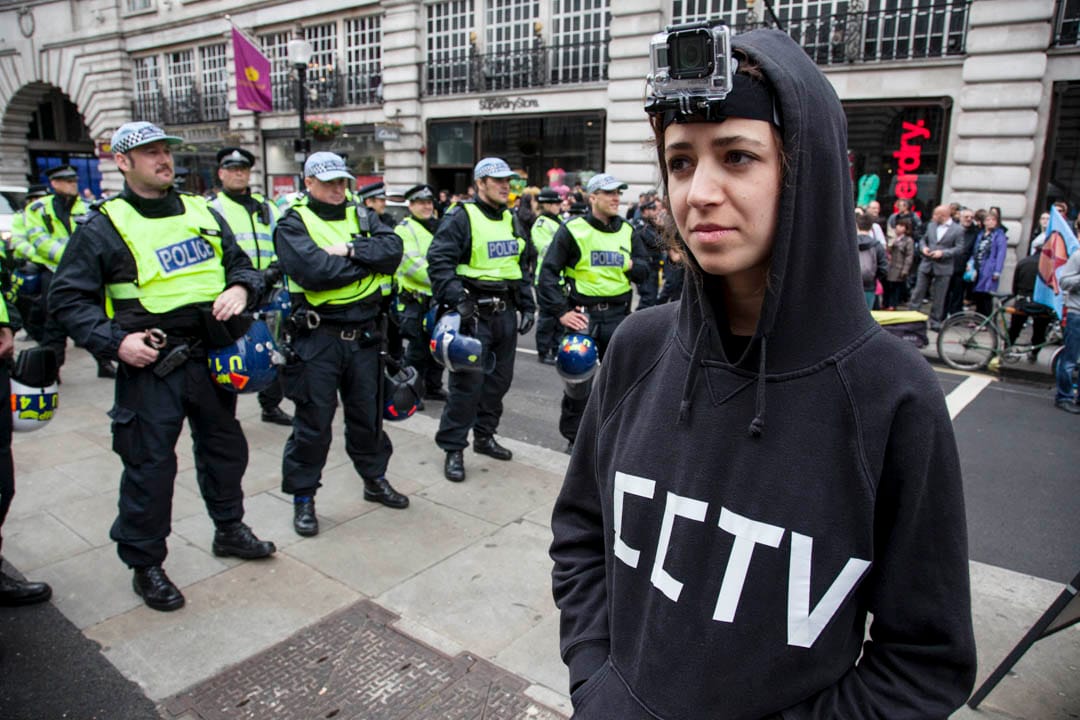 2013年6月11日，英國倫敦舉行的 G8 峰會示威期間，示威者將閉路電視攝像機綁在頭上拍攝警察。