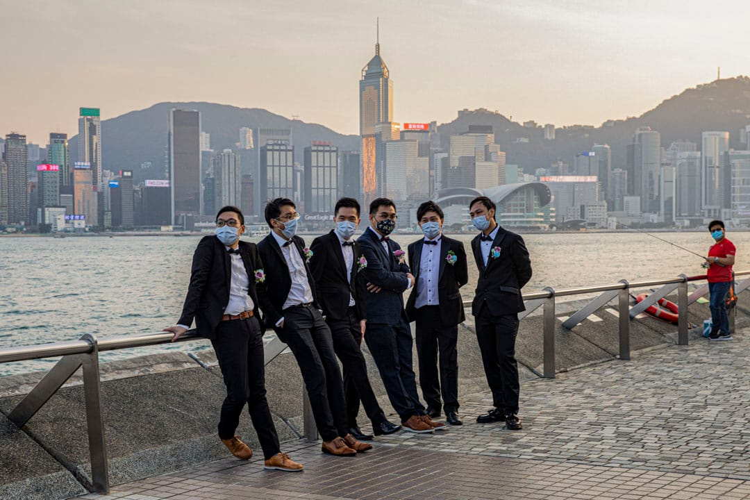 2020年11月1日，尖沙咀，新婚新郎和兄弟們戴著口罩在維多利亞港海旁等待拍照。