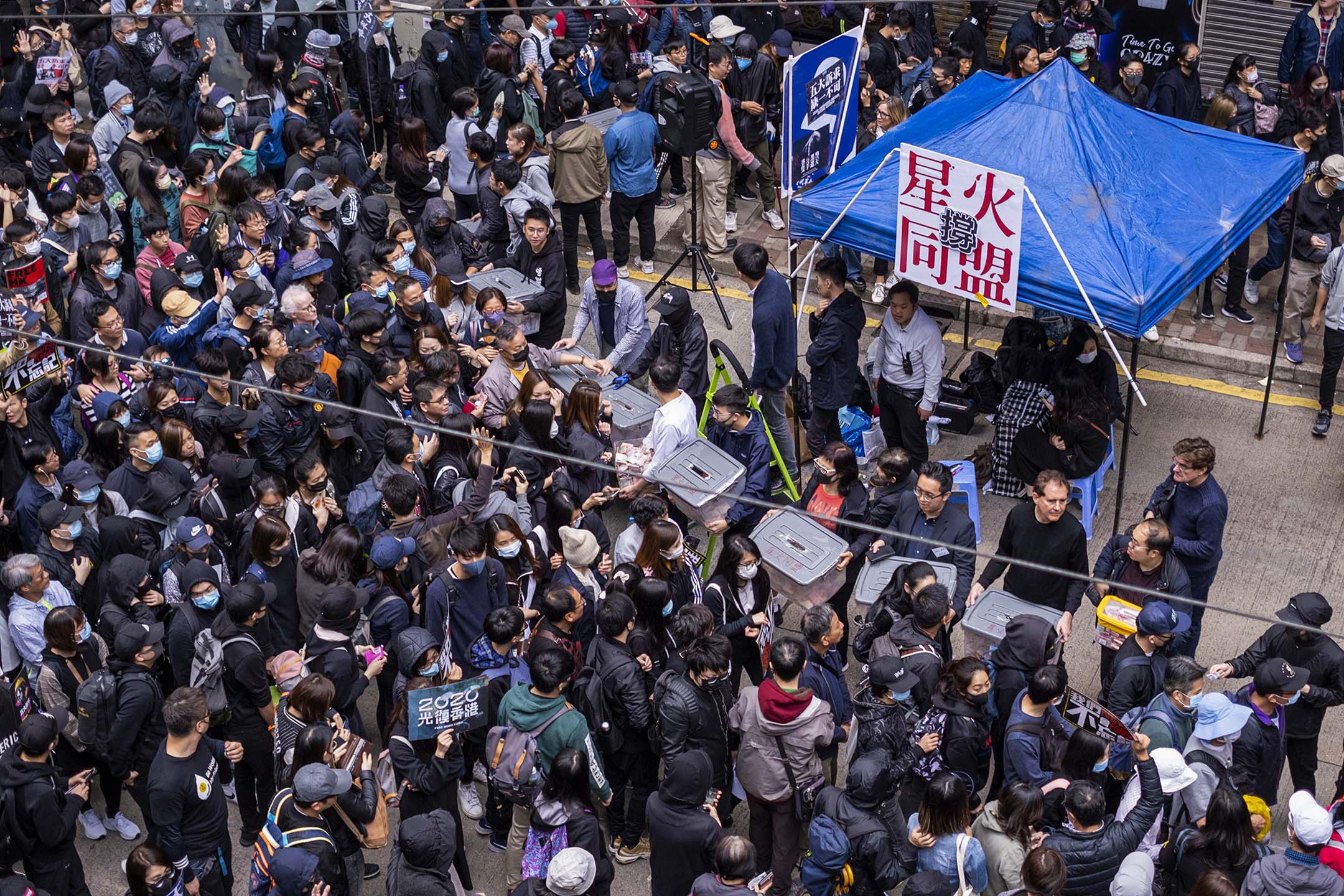 2020年1月1日,香港銅鑼灣區軒尼詩道的示威活動中,示威者在遊行時經過「星火同盟」的一個攤位。攝:Justin Chin/Bloomberg via Getty Images