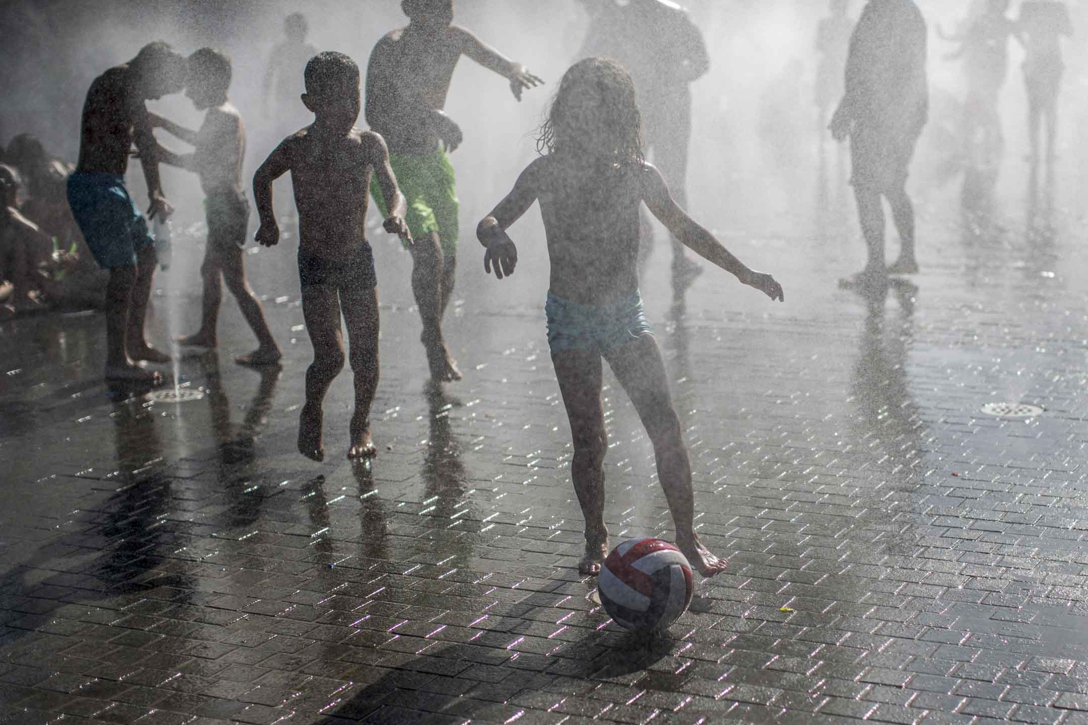 2023年7月9日，西班牙馬德里，孩子們在噴水池中間玩樂。攝：Luis Soto/SOPA Images/LightRocket via Getty Images