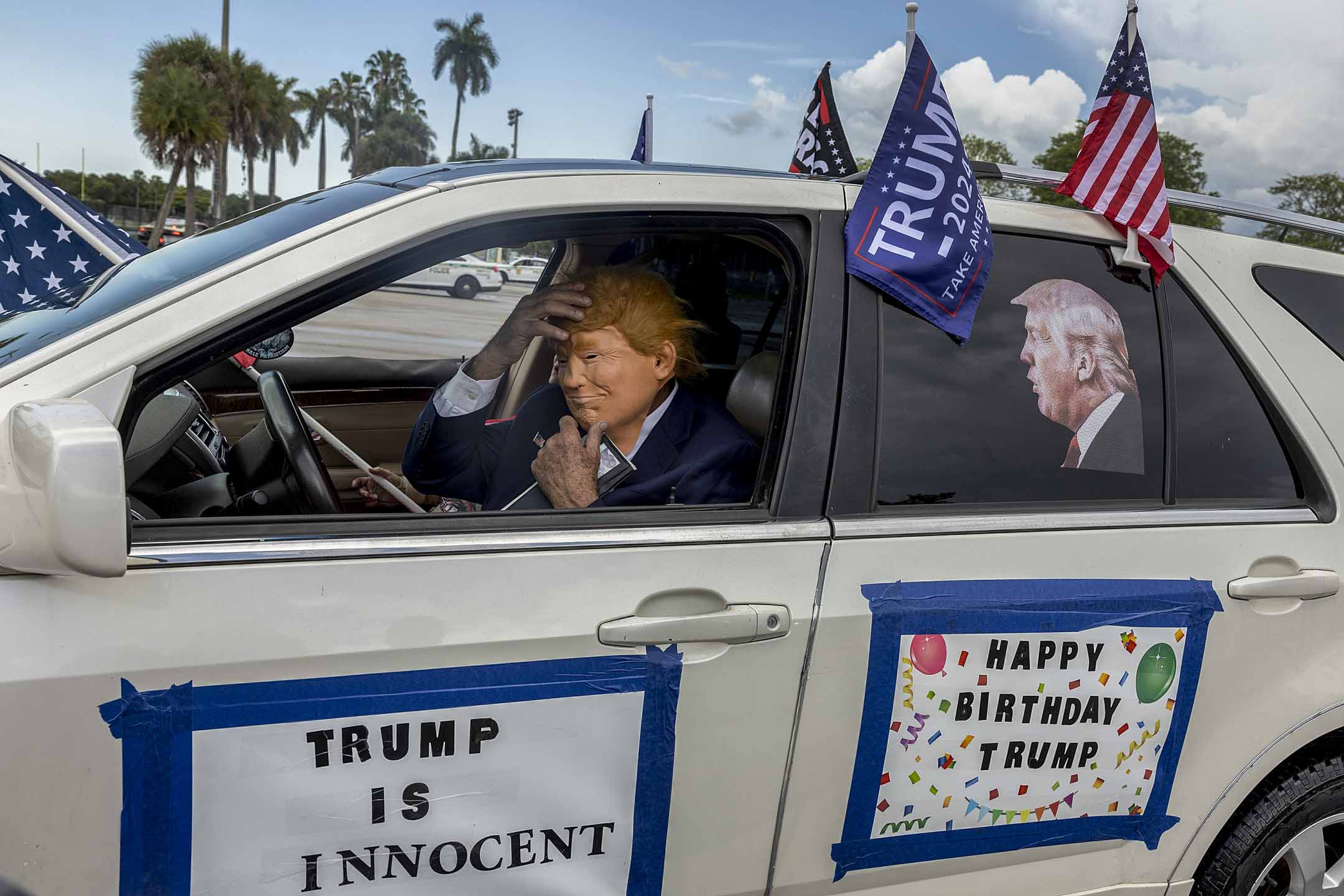 2023年6月11日，佛羅里達州邁阿密，朗普持支特者戴上面具祝他生日快樂。攝：Joe Raedle/Getty Images