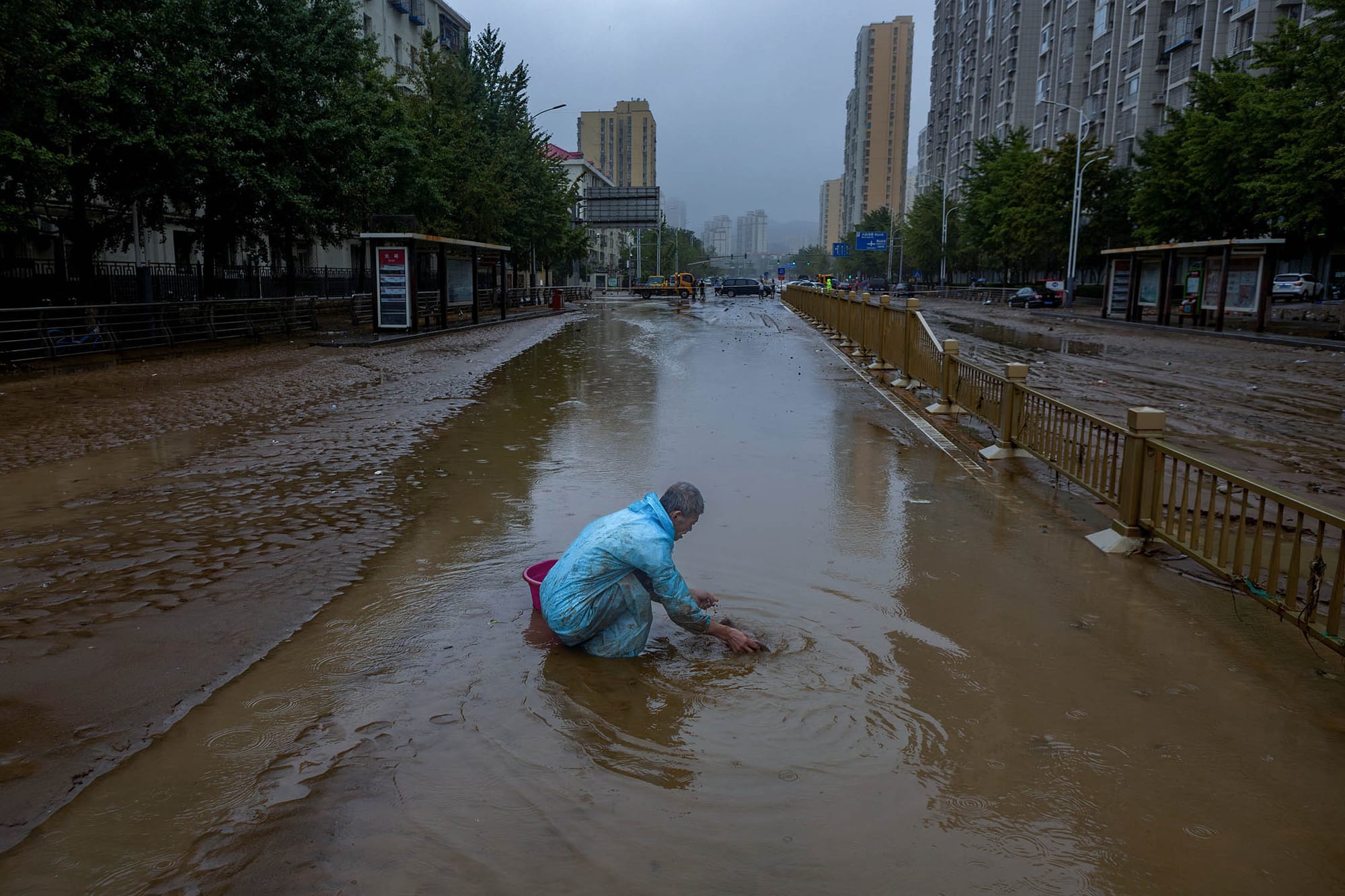2023年8月1日,北京,一名男子在一條被洪水淹沒的街道上。攝:Thomas Peter/Reuters/達志影像