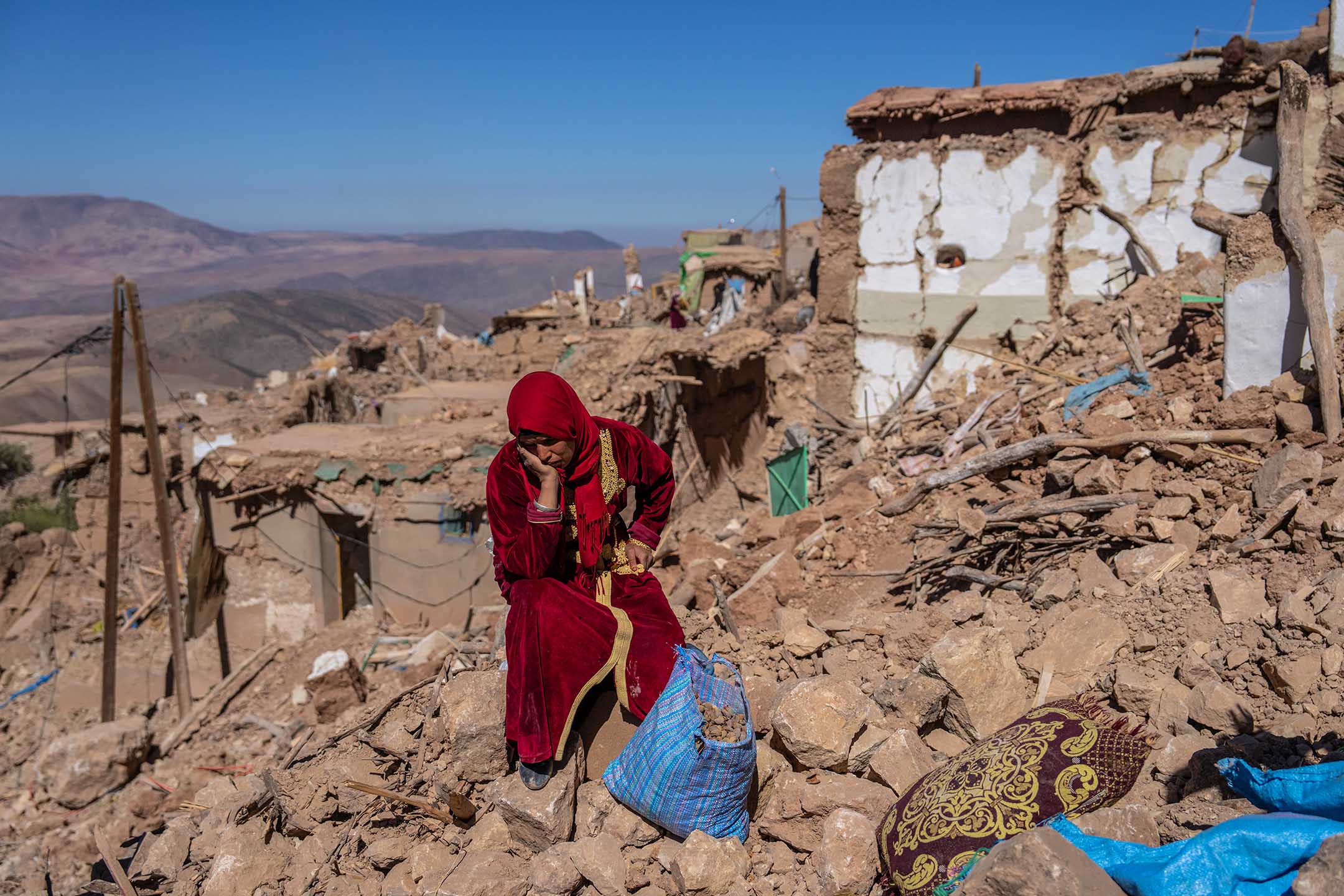 2023年9月11日,摩洛哥杜兹鲁,地震后,一名妇女坐在被地震摧毁的村庄中。摄:Carl Court/Getty Images