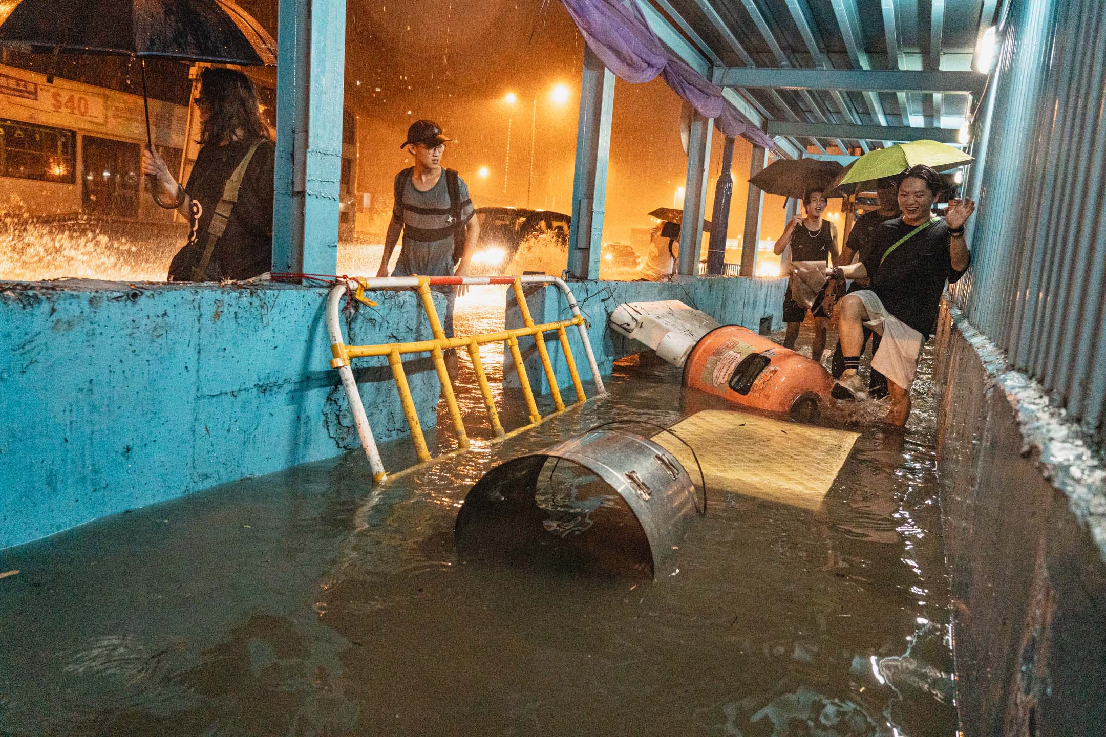 2023年9月8日,自有纪录以来最大暴雨,,有市民涉水而行,水面飘浮著围栏、垃圾桶等杂物。摄:Ryan Lai/端传媒