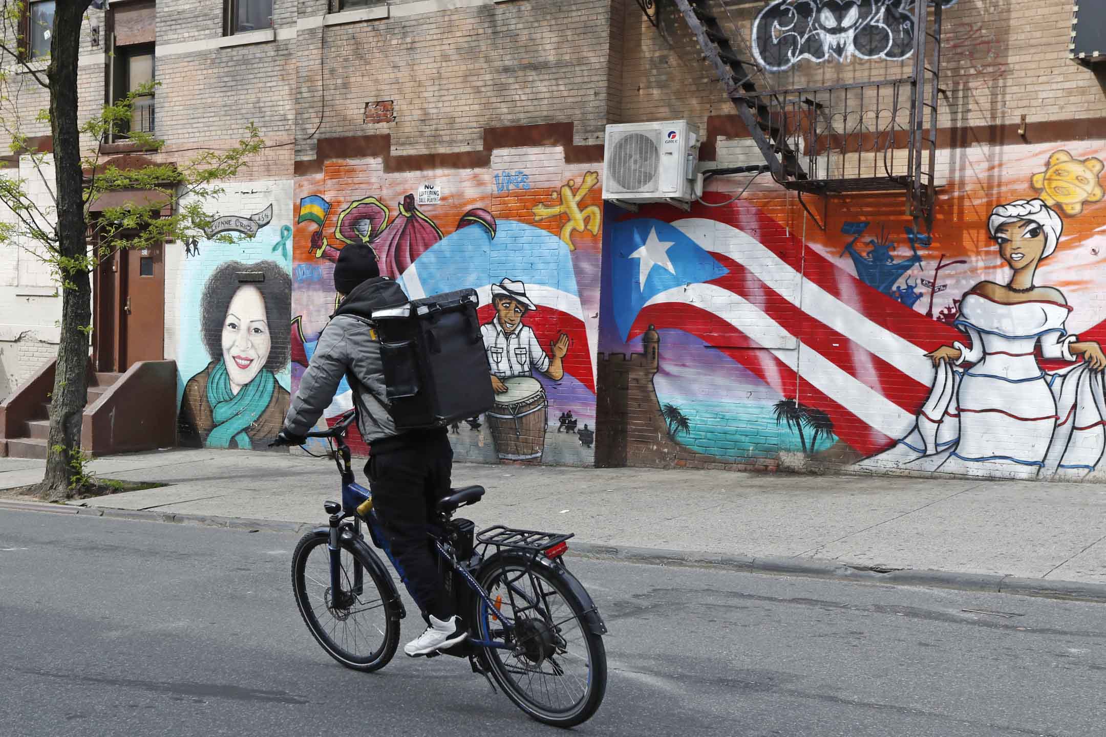 2020年5月11日,美國紐約,一名騎自行車的送貨員沿著布魯克林日落公園附近的街道騎行。攝:Kathy Willens/AP/達志影像