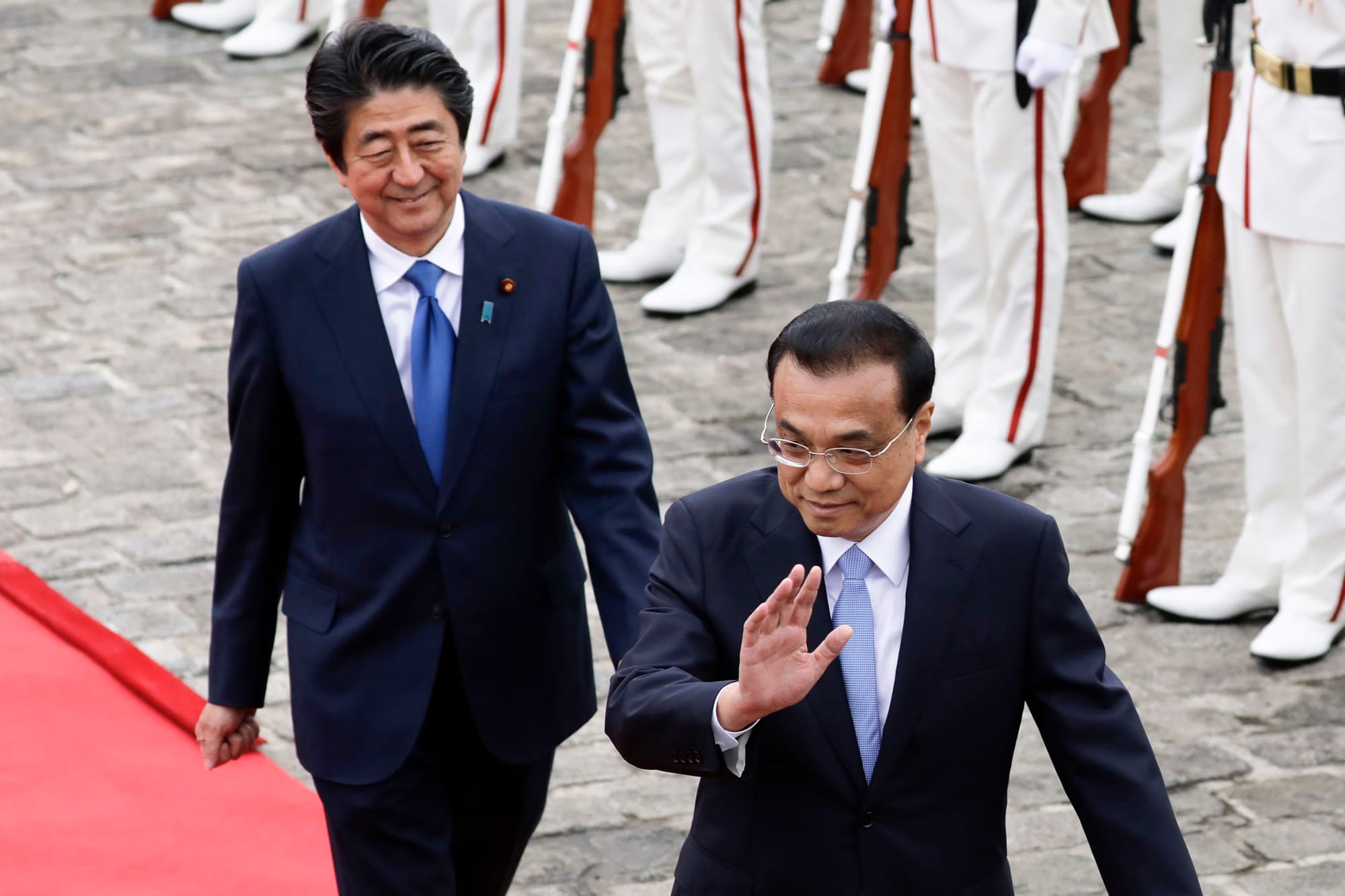 2018年5月9日，日本东京，中国国务院总理李克强与日本首相安倍晋三检阅仪仗队时向客人挥手致意。摄：Kiyoshi Ota/Bloomberg via Getty Images