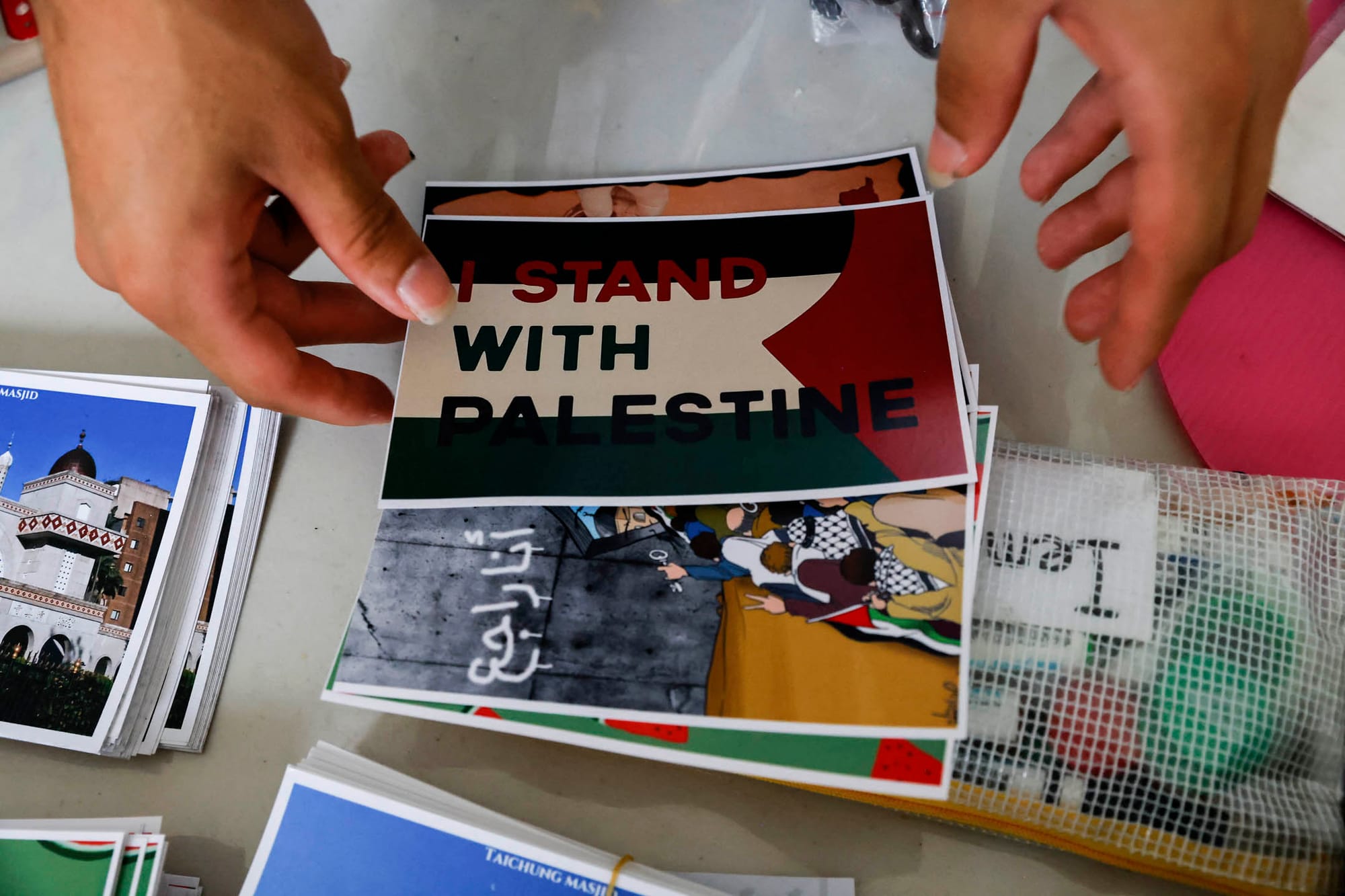 2023年10月21日，一名志工在台湾台北清真寺为巴勒斯坦人举办的慈善义卖活动中售卖明信片。摄：Ann Wang/Reuters/达志影像