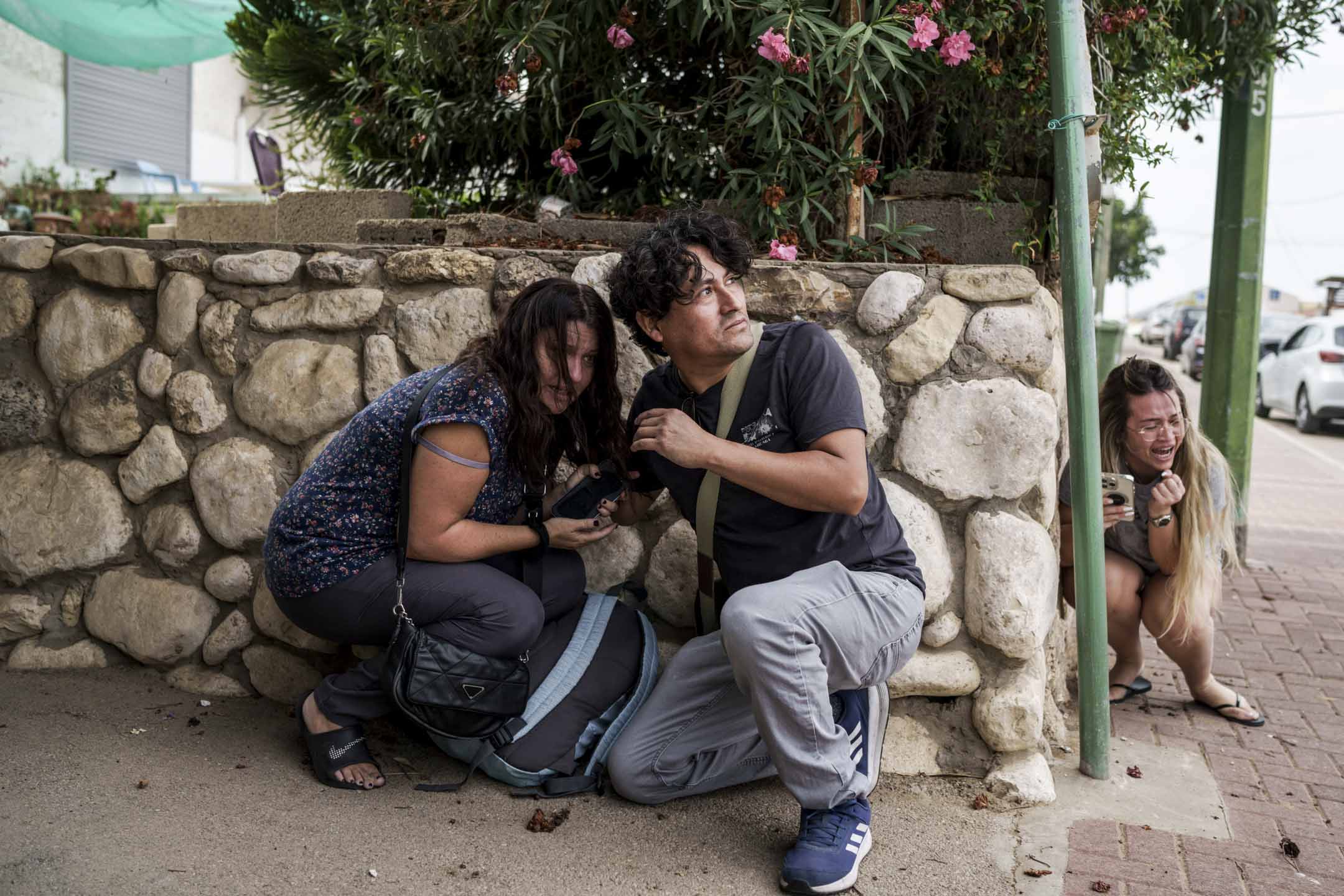 2023年10月11日,以色列南部阿什凱隆,當地人在躲避來自加沙地帶的火箭襲擊。攝:Leo Correa/AP/達志影像