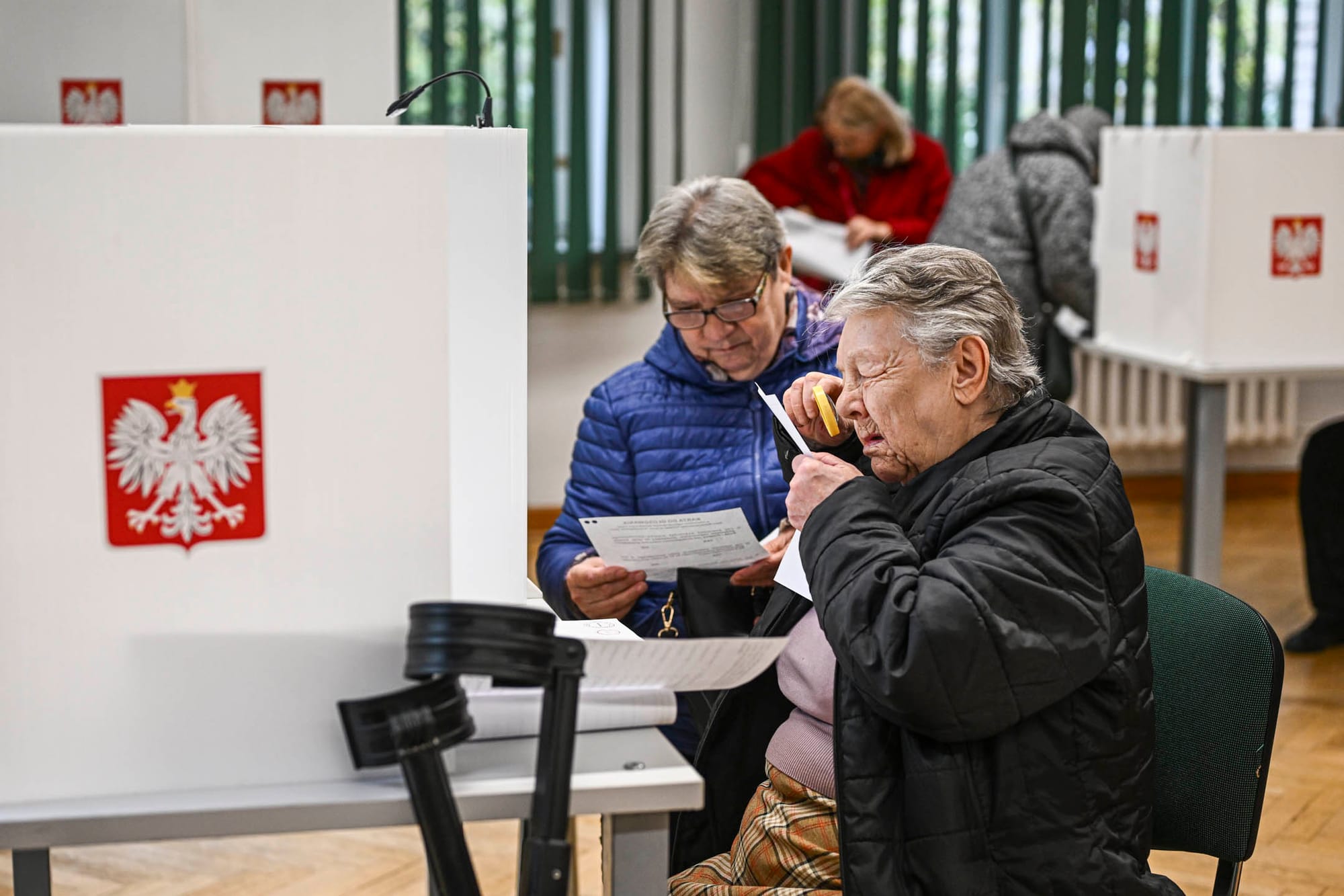 2023 年 10 月 15 日,波兰,波兰议会选举期间,一名妇女用放大镜看选票。摄:Omar Marques/Getty Images