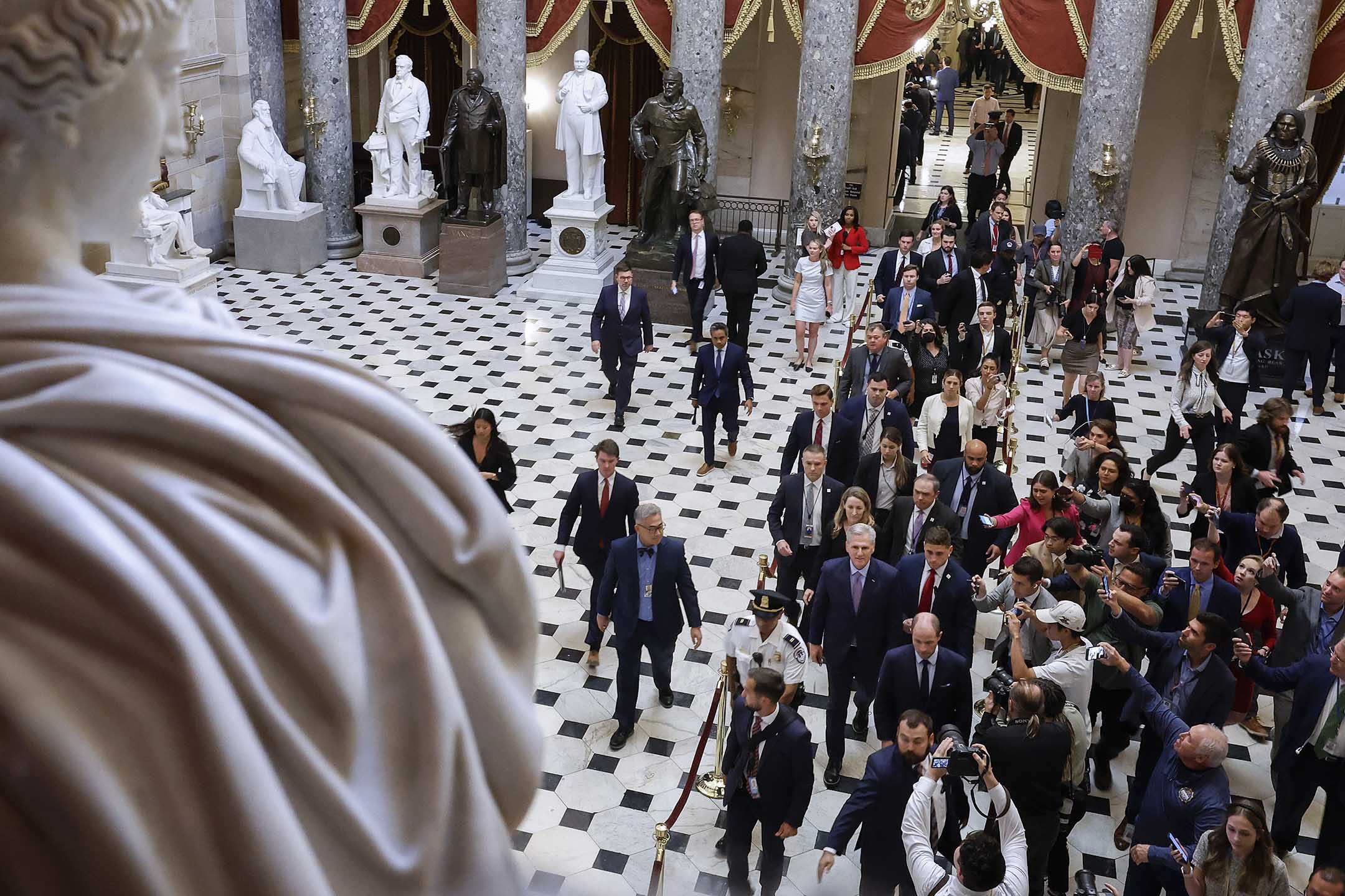 2023年10月3日,前眾議院議長麥卡錫於華盛頓的美國國會大廈被驅逐後走過大廳,圍繞著工作人員、保安和記者。