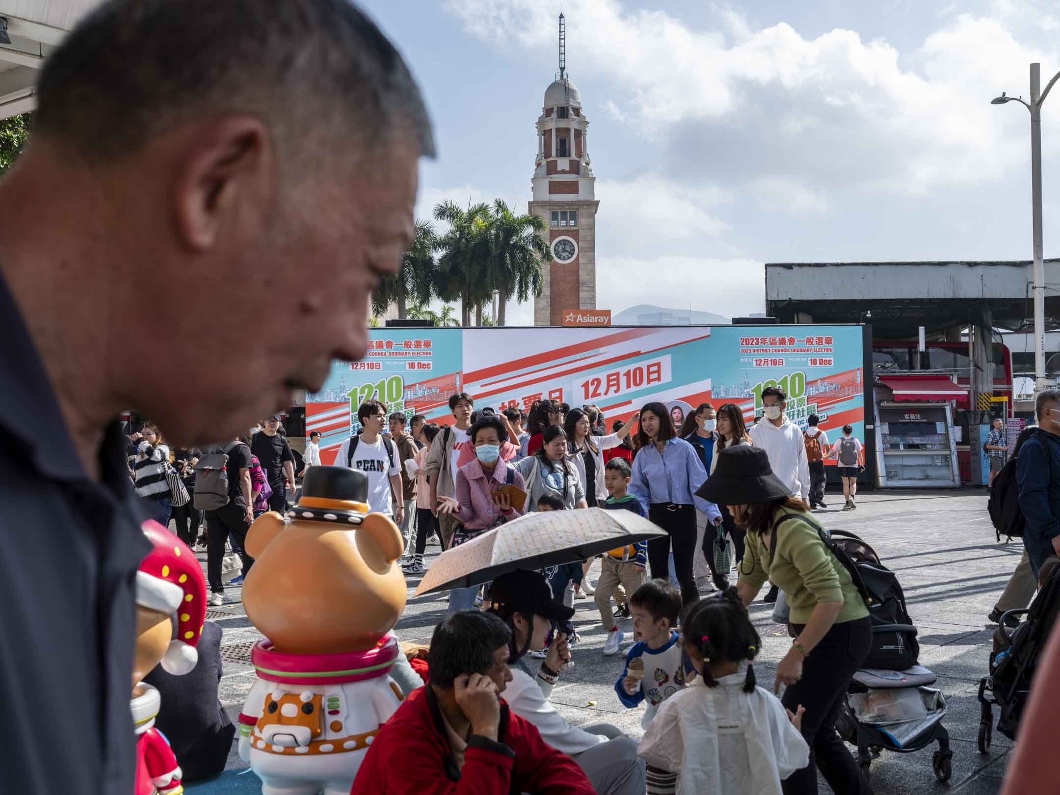 2023年12月9日,尖沙咀碼頭外有屏幕播放呼籲區議會投票的影片。攝:林振東/端傳媒