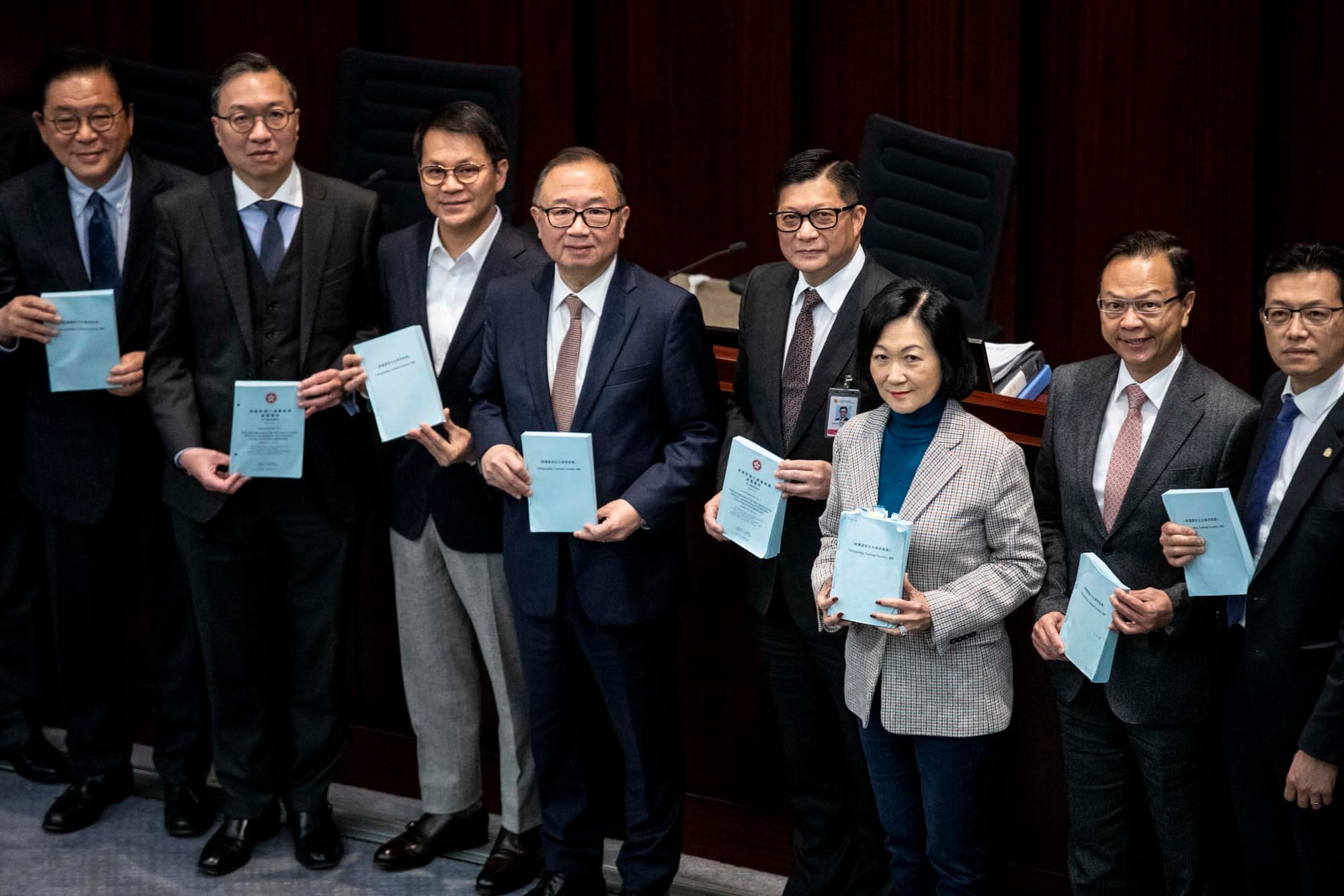 2024年3月14日，立法會法案委員會經過約一週會議後，完成逐條審議《維護國家安全條例草案》，會後律政司司長林定國與保安局局長鄧炳強跟議員合照。攝：林振東/端傳媒  