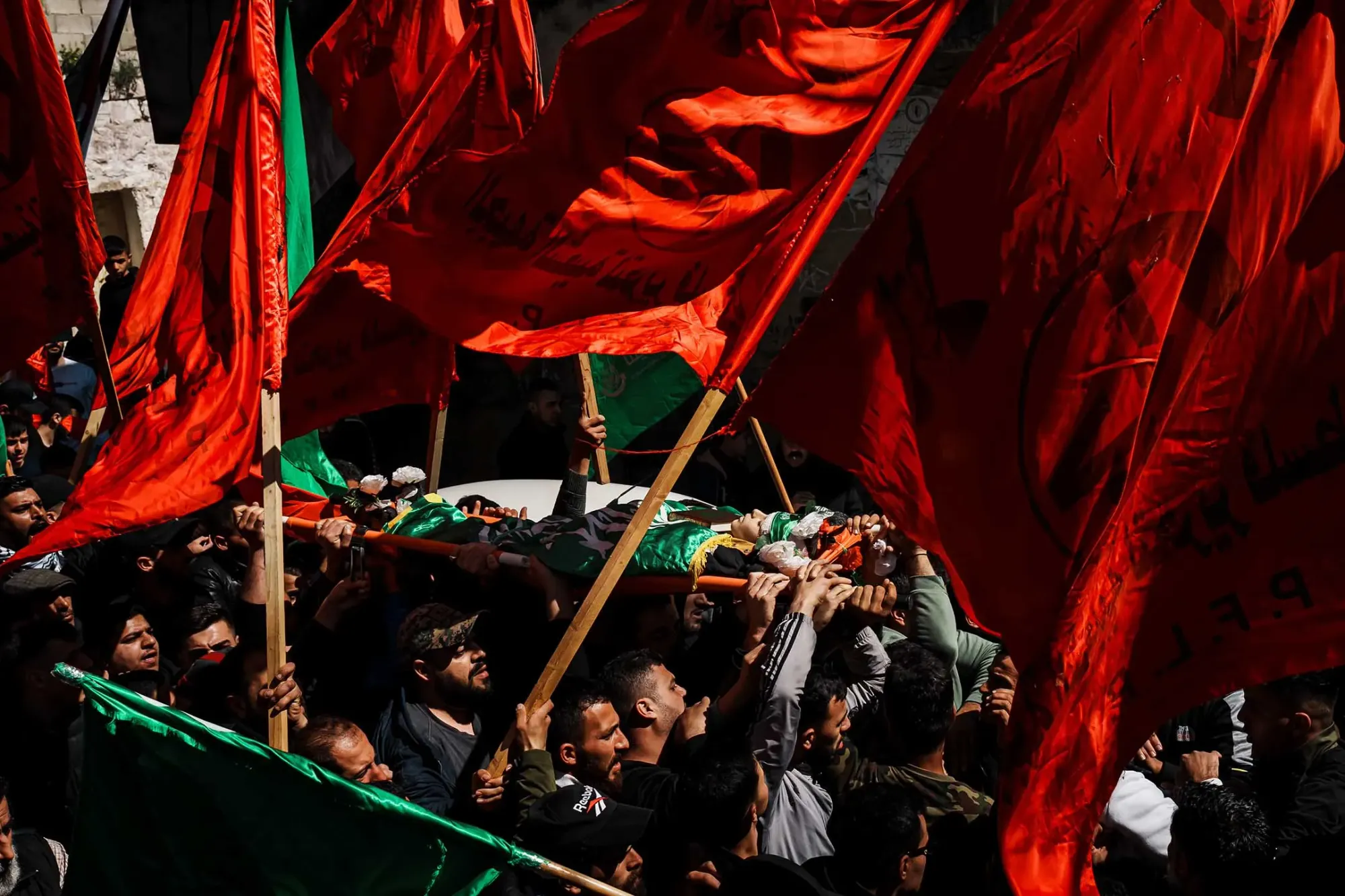 2024年3月5日,约旦河西岸的送葬队伍中,亲友抬著儿童的尸体,他被以色列军队杀害。摄:Marcus Yam/Los Angeles Times/达志影像