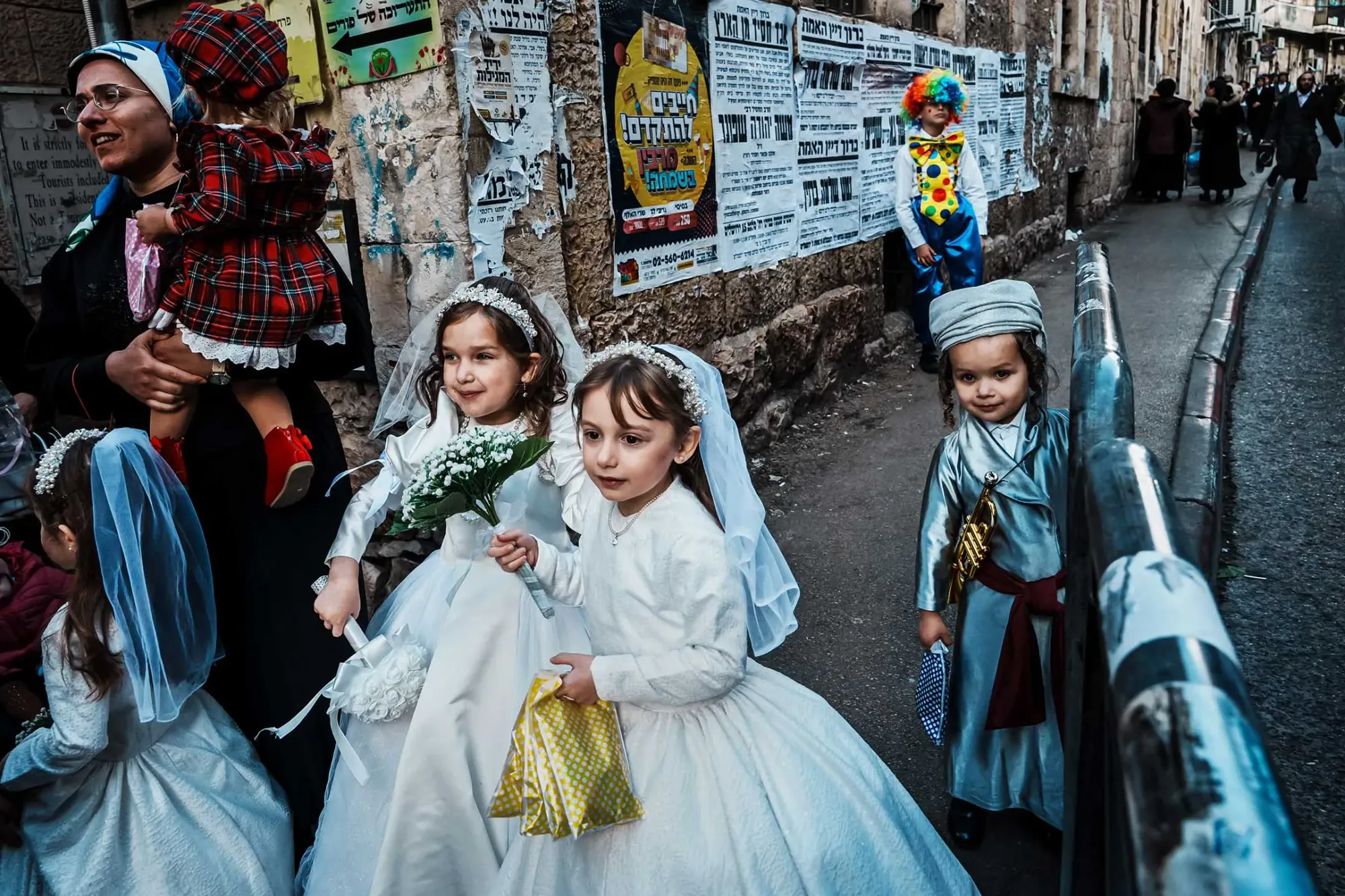 2024年3月25日,穿著婚纱的年轻女孩与家人在以色列耶路撒冷的街道上漫步,参加普珥节活动。摄:Marcus Yam/Los Angeles Times/达志影像