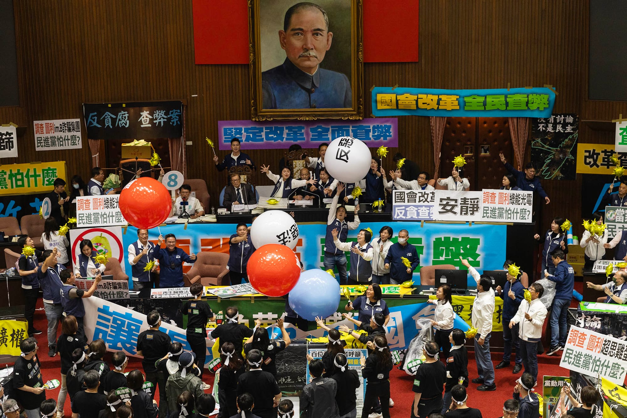 2024年5月28日,台北,立法院进行国会改革法案审议,立法院内民进党立委向主席台抛汽球。摄:陈焯煇/端传媒