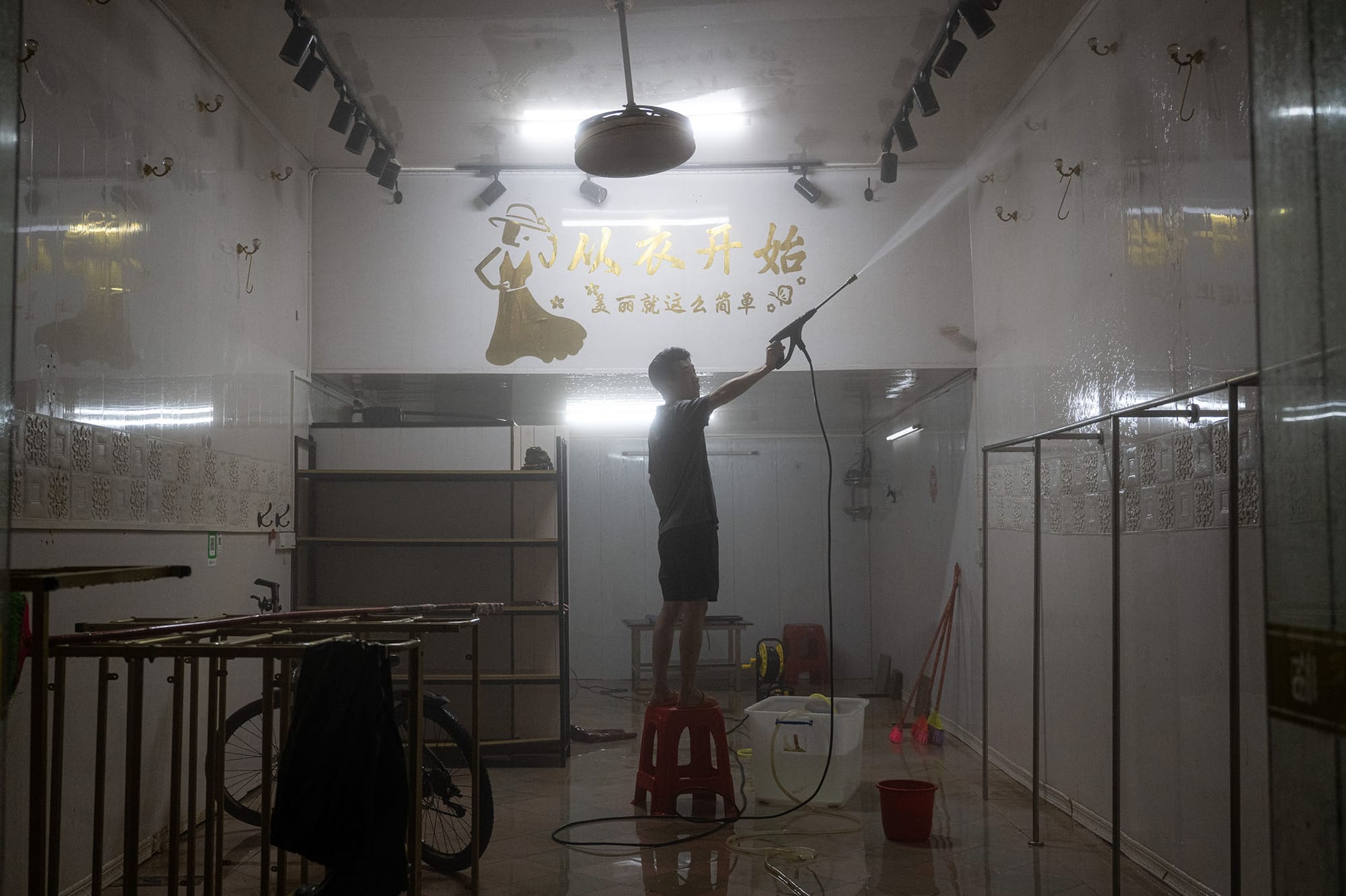 2024年6月19日,中國梅州,暴雨引發洪水,村民清理商店。攝:John Ricky/Anadolu via Getty Images