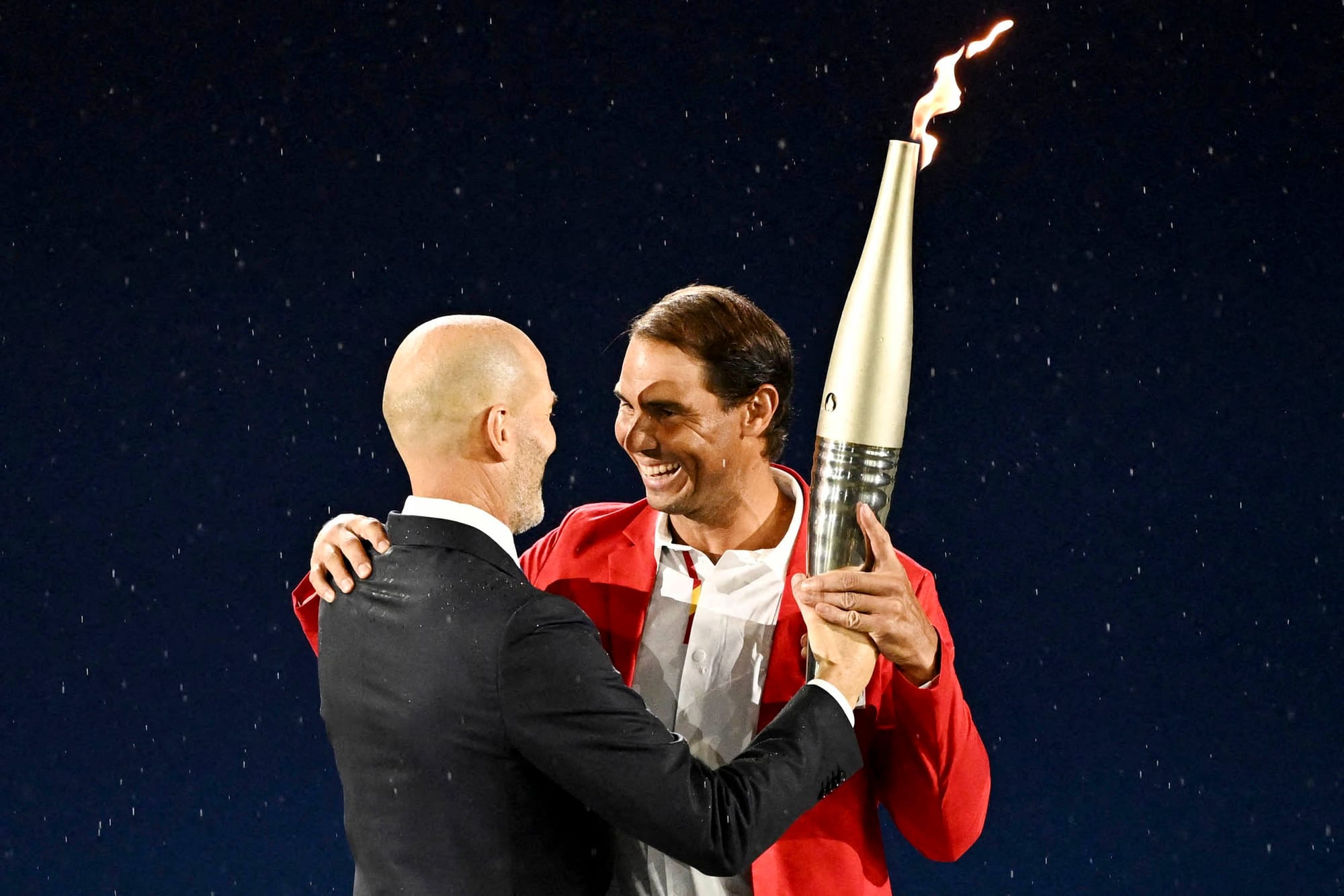 2024年7月26日，法国足球名宿施丹将火炬传给网球名将拿度。摄：Dylan Martinez/Reuters/达志影像